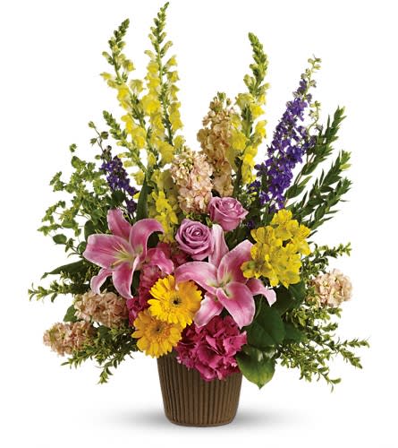 Glorious Grace Bouquet - Celebrate the spirit of a loved one who is no longer with us with a gorgeous array of roses lilies and other favorites. The magnificent bouquet includes pink hydrangea lavender roses pink oriental lilies yellow gerberas yellow alstroemeria yellow snapdragons purple larkspur and peach stock accented with assorted greenery. Delivered in a stylish urn.