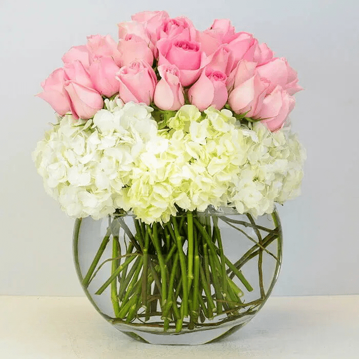 Pink Blossom Delight - Imagine a delicate symphony of nature's beauty captured in a feminine pink and white flower arrangement. Soft hues of blush and ivory dance gracefully together, forming a harmonious composition that evokes tranquility and elegance. This arrangement, with its gentle colors and graceful arrangement, is a timeless expression of grace and femininity, perfect for any occasion that calls for beauty and serenity.