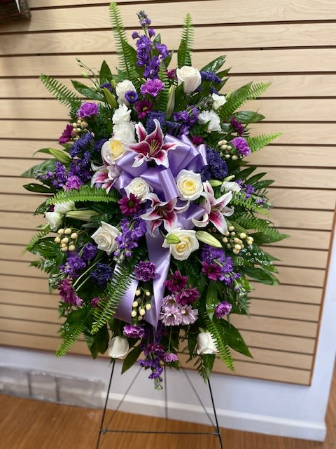 Mixed Purple and White Standing Spray - Purple and white funeral standing spray with white roses, purple daisies, purple carnations, stargazer lilies, white berries, and lavender daisies.