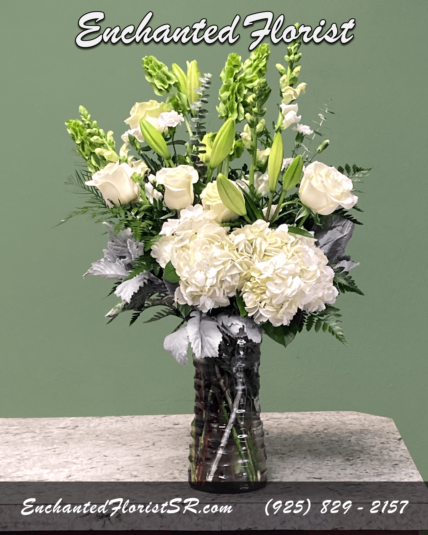 Hi-Def Hydrangeas - Mixed Arrangement - A serene mixed arrangement that showcases a white and green palette, featuring two lush bunches of hydrangeas blended with astatic lilies, snapdragons, carnations, and roses. Accented with a symphony of greenery including leather fern, lemon leaf, 'Bells of Ireland', 'spiral' eucalyptus, and lush Dusty Miller.  Arrives In: cylindrical clear glass vase  Orientation: Any-Sided  Approximate Dimensions: 26&quot; Tall 14&quot; Wide 6&quot; Vase Diameter