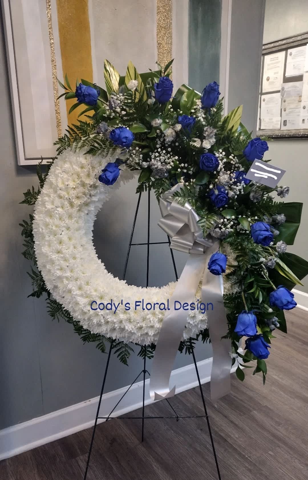 Serenity Wreath - Meaningful arrangement which symbolizes the circle of life is appropriate for a funeral service to show your enduring respect and admiration for a loved one. Fresh flowers such as white lilies, yellow roses, carnations, daisy's, baby's breaths and greenery.