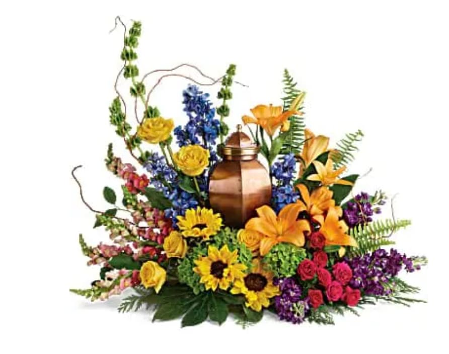 With All Our Hearts Cremation Tribute With All Our Hearts Cremation Tribute - Like a radiant rainbow on a gray day, this colorful bouquet of hydrangea, roses, and sunflowers brings a bright light of hope to the cremation urn and celebration of life. This colorful arrangement includes green hydrangea, yellow roses, hot pink spray roses, orange asiatic lilies, yellow sunflowers, bells of Ireland, blue delphinium, orange snapdragons, purple stock, curly willow, cedar stem, sword fern, aralia leaf, and lemon leaf. Arrangement does not include urn.