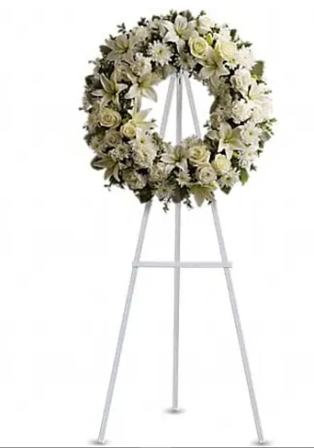 Serenity Wreath - A ring of fragrant, bright white blossoms will create a serene display at any funeral or wake. This classic wreath is delivered on an easel, and is a thoughtful expression of sympathy and admiration. A standing wreath created from fresh white flowers such as roses, Asiatic lilies, carnations and cushion spray chrysanthemums - accented with greenery - is delivered on an easel.Approximately 22&quot; W x 22&quot; H