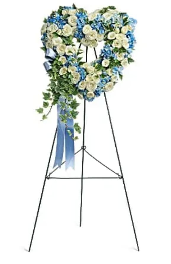 Pure Heart Pure Heart - Adorned with trailing ivy, this petite, 16" sweet heart-shaped wreath of sky blue hydrangea and pure white roses is a loving remembrance. This heartfelt arrangement features blue hydrangea, white spray roses, and variegated ivy. Delivered on a wire easel.