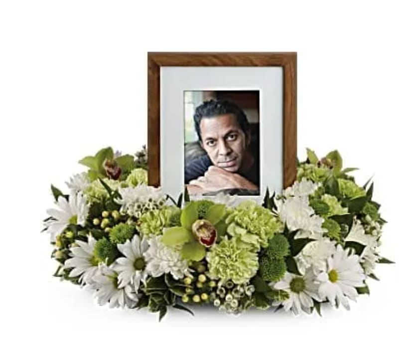 Garden Wreath - An exquisite round wreath with blooms inspired by the lasting impressions a loved one makes on our lives. Surround a treasured photograph, poem or other dear memento with sweet, green carnations, white and green chrysanthemums and the special beauty of green cymbidium orchids. This luxurious wreath includes flowers such as carnations, chrysanthemums, silky green cymbidium orchid blossoms and variegated greenery. Please note: Arrangement does not include picture frame.