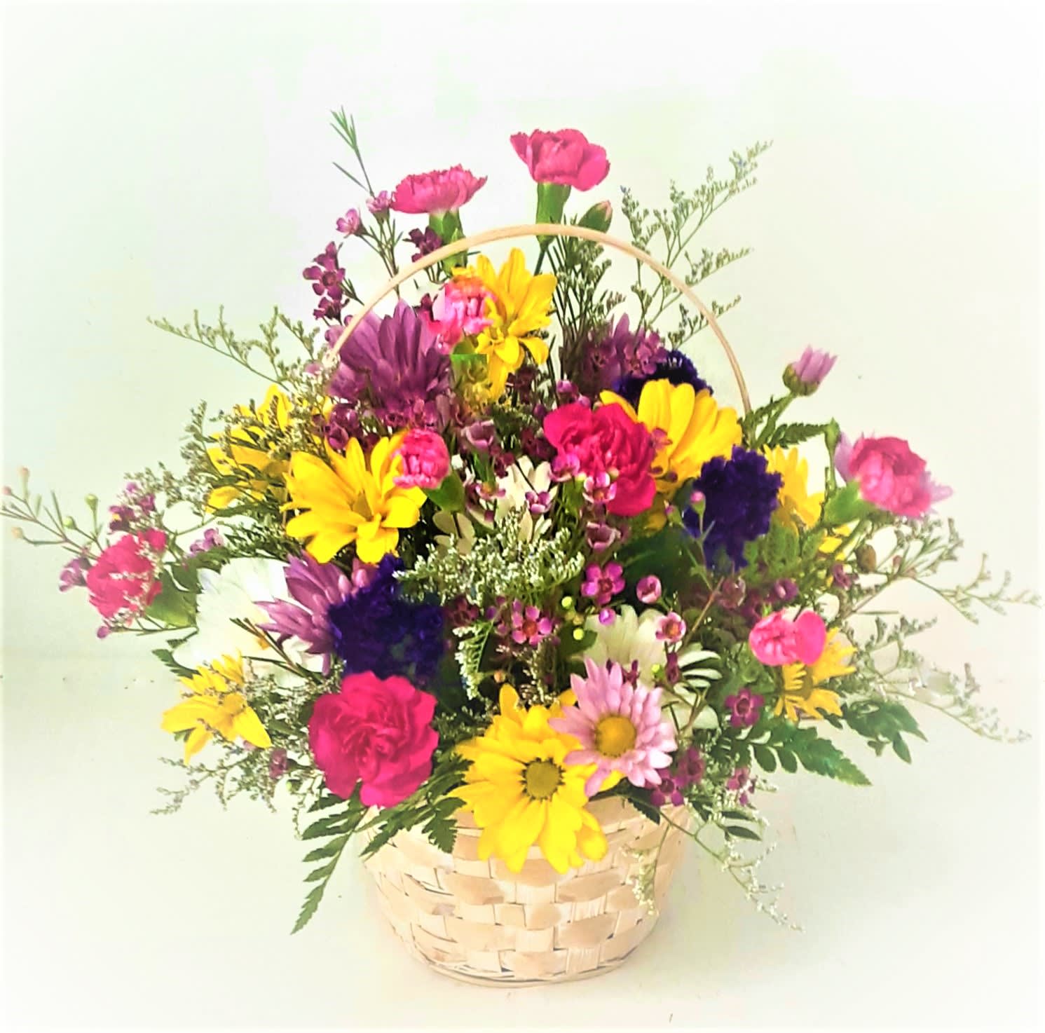 Sweetest Day Basket - Simple and long lasting flowers such as assorted daises, mini carnations, statice, and lacy fillers in a cute basket with a handle .Perfect for the young at heart.