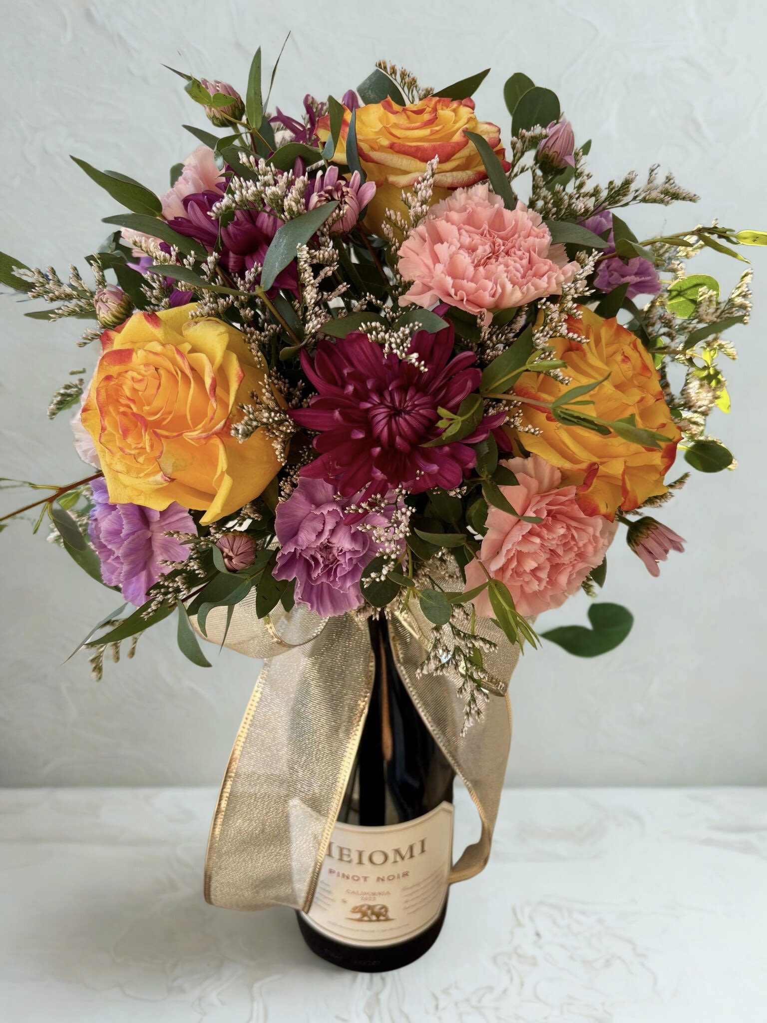 Chardonnay Bouquet - Bright array of flowers paired with a bottle of wine. Note that flower colors will vary.  *Choice of Chardonnay, Pinot Noir or Moscato (If no wine is mentioned in the comments, we will select whatever is available)*