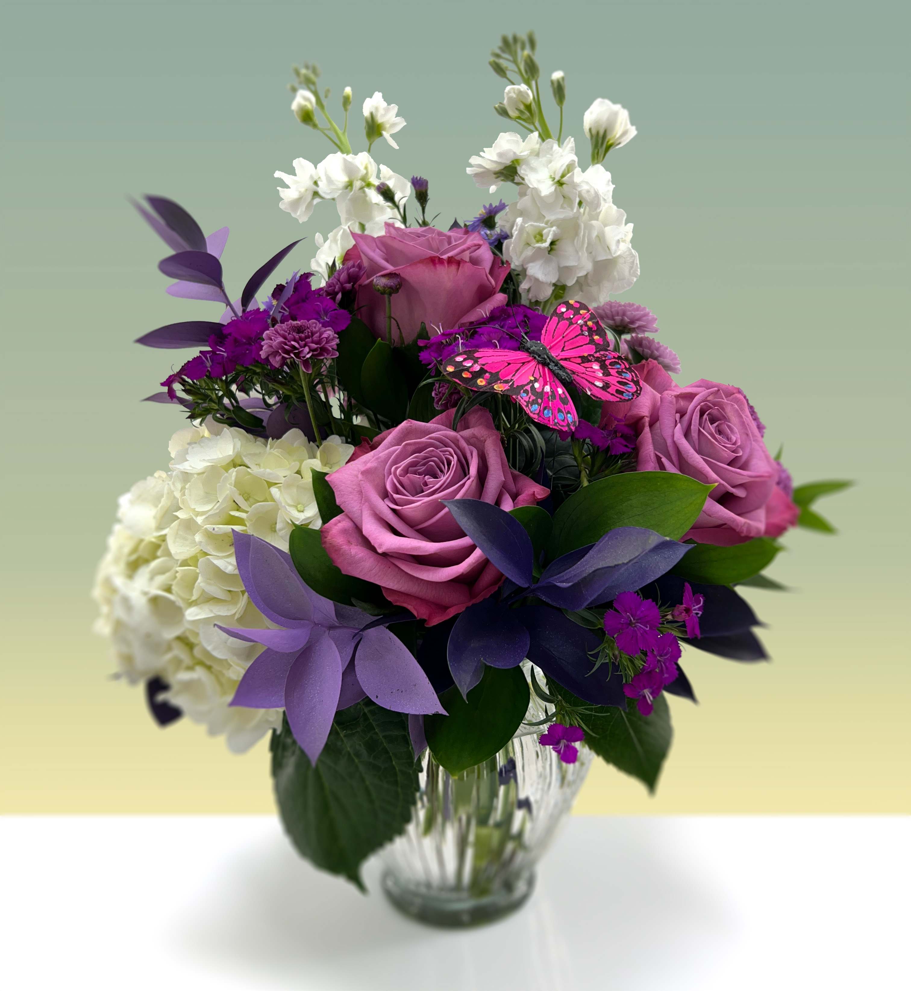 Big Hug - Give a big hug when gifting this bouquet of lavender roses, hydrangeas, dianthus, and ruscus. Adorned with an ornamental butterfly.