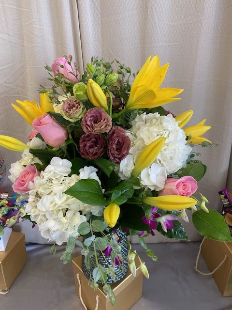  A Touch of Summer  - Beautiful mixed arrangement  that will brighten that special someone's day and lighten up the room . This arrangement consists of fluffy white hydrangeas, yellow lilies, purple dendrobium orchids, light pink roses , purple  lisianthus and a mixture of greenery including eucalyptus, leather and lemon.    