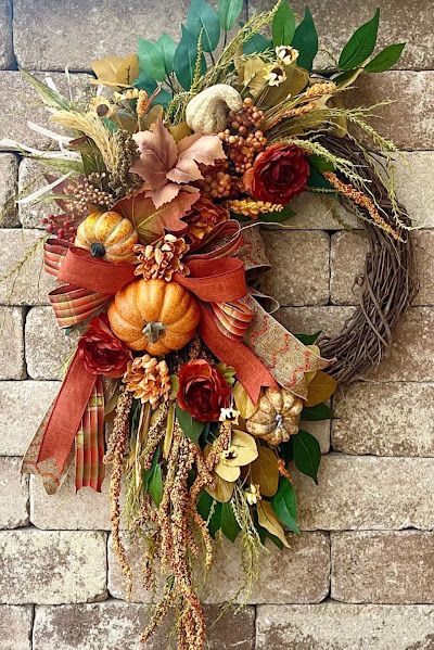 Autumn Wreath Autumn Wreath - Enhance your front door with this exquisite Fall Wreath, a perfect touch of autumn elegance. This Autumn Farmhouse Wreath features a delightful combination of pumpkins, gourds, and terracotta hues, creating a warm and inviting atmosphere for your home. An orange, green, and yellow plaid bow adds a charming seasonal touch, while hanging berries add a whimsical detail. The natural elements are artfully arranged to highlight the beauty of the harvest season, making it an ideal decoration for Thanksgiving and throughout the fall.
