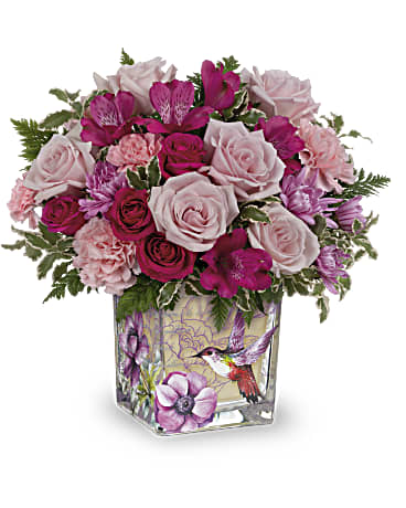 Teleflora's Sweet Hummingbird Bouquet - Like a hummingbird flitting around a secret garden, this delightful bouquet of pink roses in a vintage-inspired glass cube is a magical gift on Mother's Day or any special occasion.