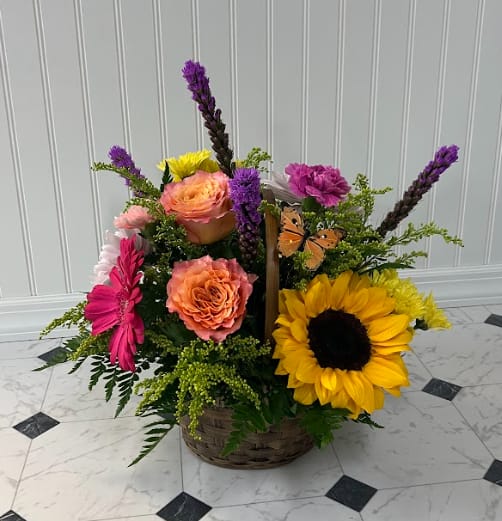 Sunny Cheer Basket - Our Sunny Cheer Basket includes a vibrant variety of the freshest and most colorful flowers. This arrangement can bring even the hard-to-please a smile from ear to ear. This festive basket is appropriate for many occasions, whether it be a birthday, anniversary, get well, or just because. Assorted festive colors and blooms fill the room with good vibes only!