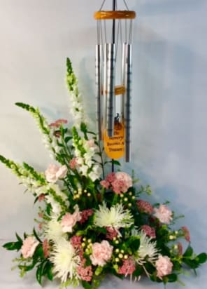 Whispering Serenity Wind Chime Bouquet - Soft and elegant, this sympathy arrangement features a delicate blend of pink and white blooms, symbolizing love, grace, and remembrance. Accented with lush greenery and paired with a soothing wind chime, this heartfelt tribute offers comfort and a gentle reminder of a loved one’s everlasting presence.  Wind Chime will vary. All chimes available have religious themes and elements.
