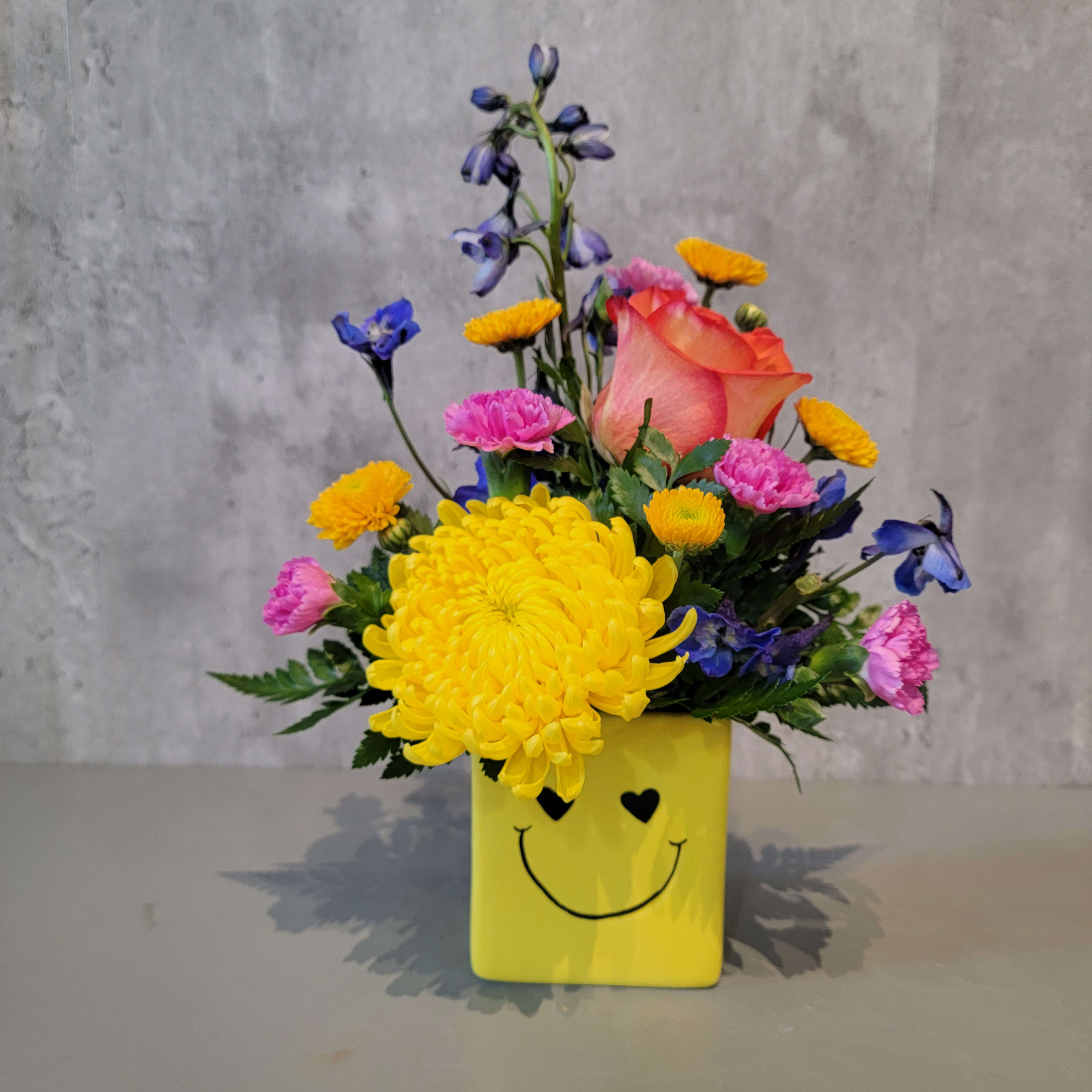 See you smile See you smile - What I wouldn't do to see you smile! Send your friend a simple, yet impactful smile today! This arrangement is approximately 12" tall and 7" wide.