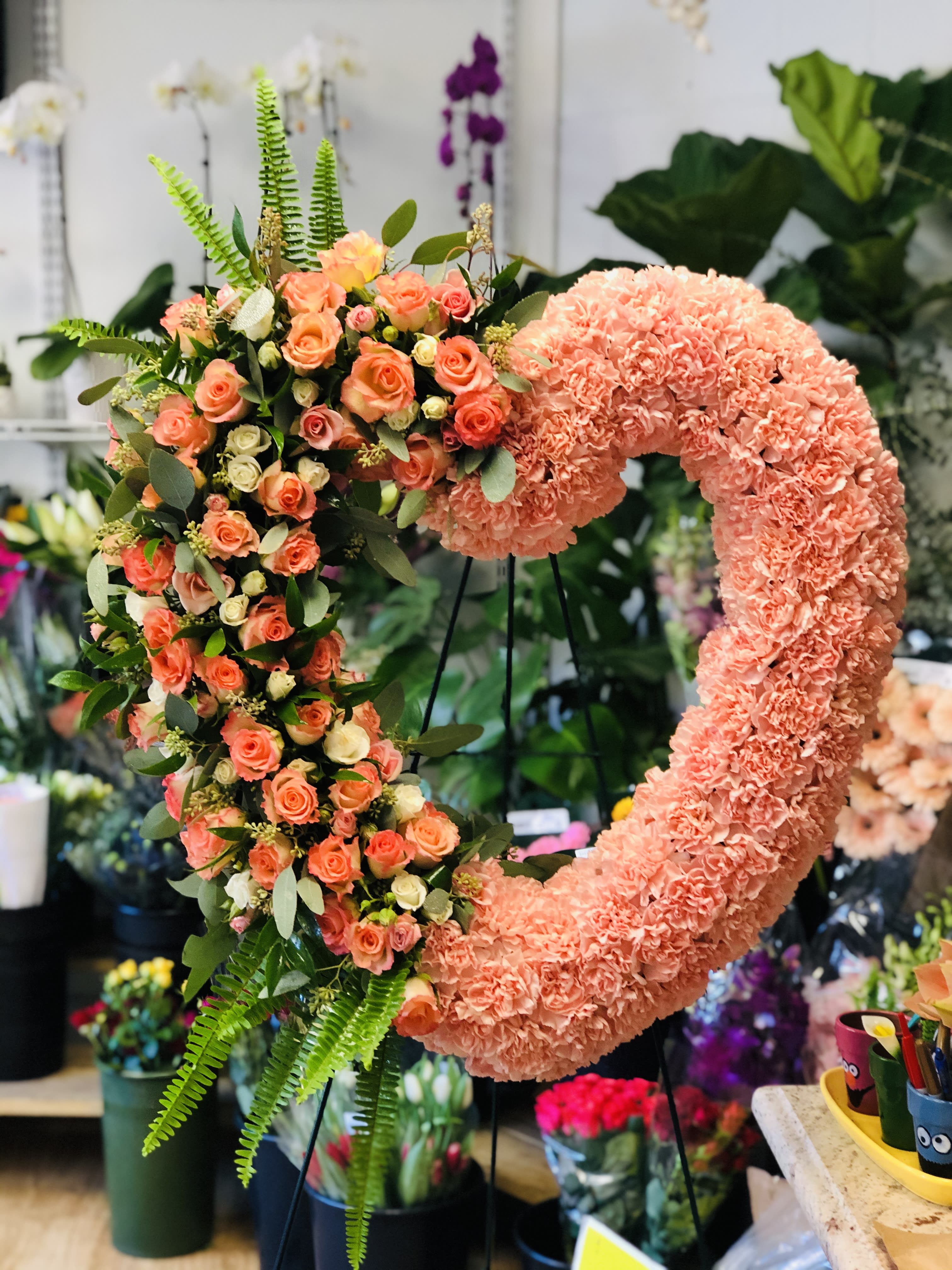 Loving Rememberance Loving Rememberance - Foliage includes: Rose, Spray Rose, Carnation, Seeded Eucalyptus and Fern Greenery We advise our customers to order 24-48 hours in advance of their scheduled delivery to ensure that we are able to have similar flowers and colors in the shop for their order. $350 (24 inches) as shown
