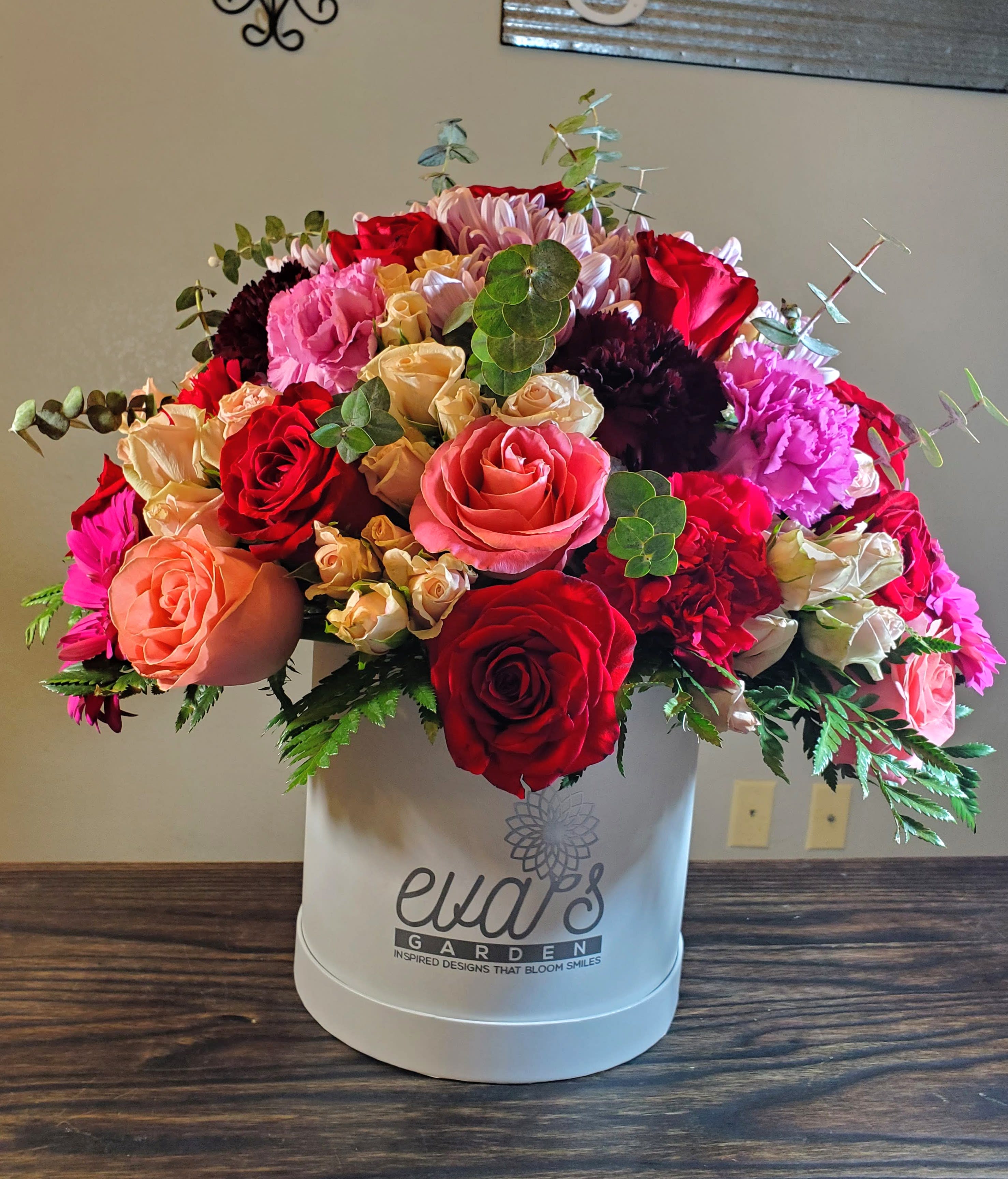 Heart's Desire Box Arrangement Heart's Desire Box Arrangement - Large hat box arrangement filled with a vivid mix of 12 light-pink spray roses, 10 red roses, 10 hot pink roses, 5 hot pink gerber daisies, 4 purple carnations, 4 red carnations, 4 burgundy carnations, 3 lavender daisies, leather leaf, and eucalyptus. Perfect as a small token of appreciation or a grand gesture of love! (Picture depicts a premium product; standard & deluxe size available upon request)