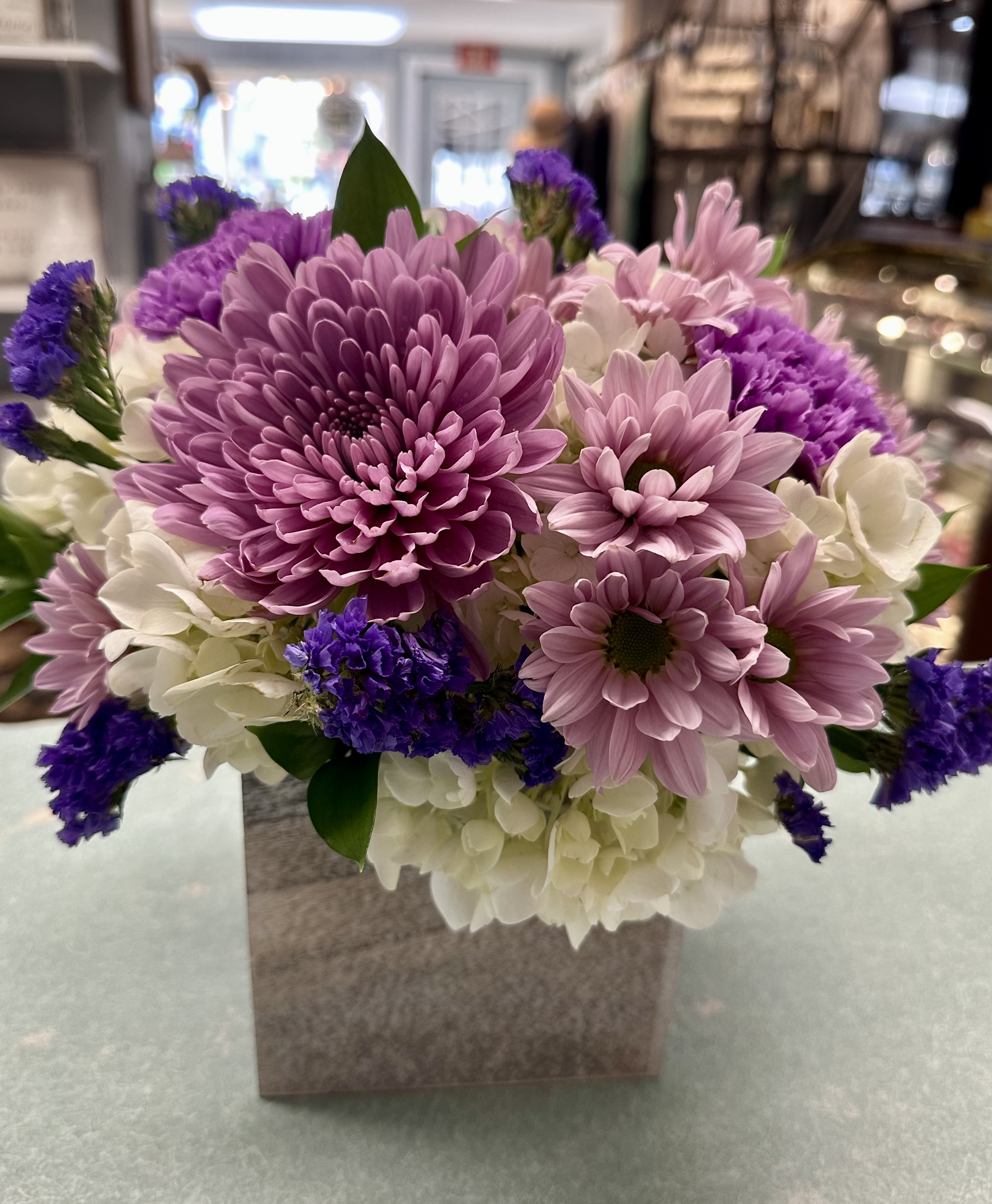 With Lavender & Love With Lavender & Love - Inspired by fields of lavender this arrangement includes white hydrangea, lavender chrysanthemums & carnations with purple statice arranged in a whitewashed wooden box