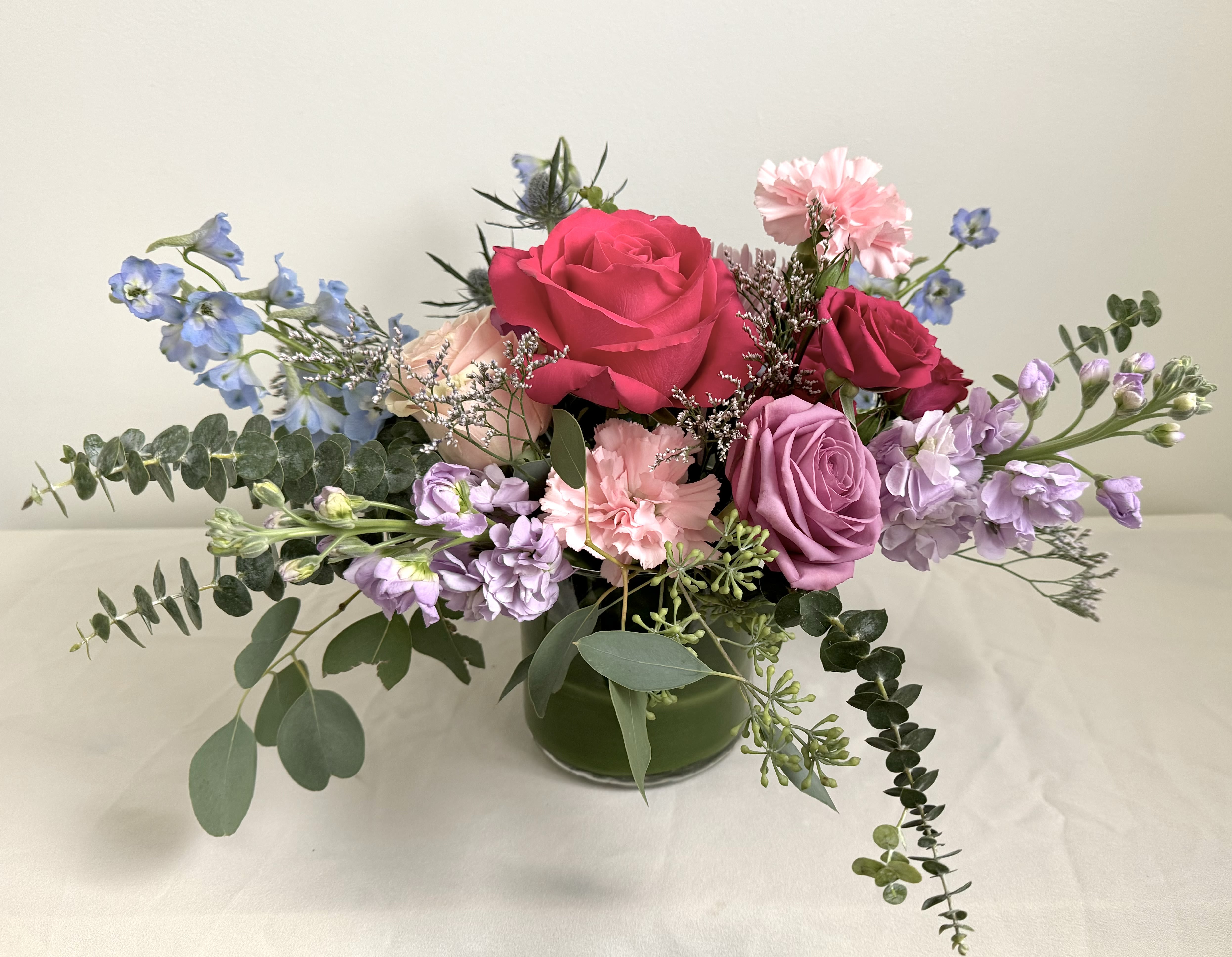  Queen of Hearts - Give the queen in your life flowers to remember with our Queen of Hearts arrangement. Pink, purple, and blue flowers arranged whimsically in a glass cylinder.   Delivery Info- Delivery Info- We make all of our deliveries after 1pm every day. If the weather is very hot or cold, we prefer not to leave the flowers outside. Please let the recipient know that they should expect delivery.