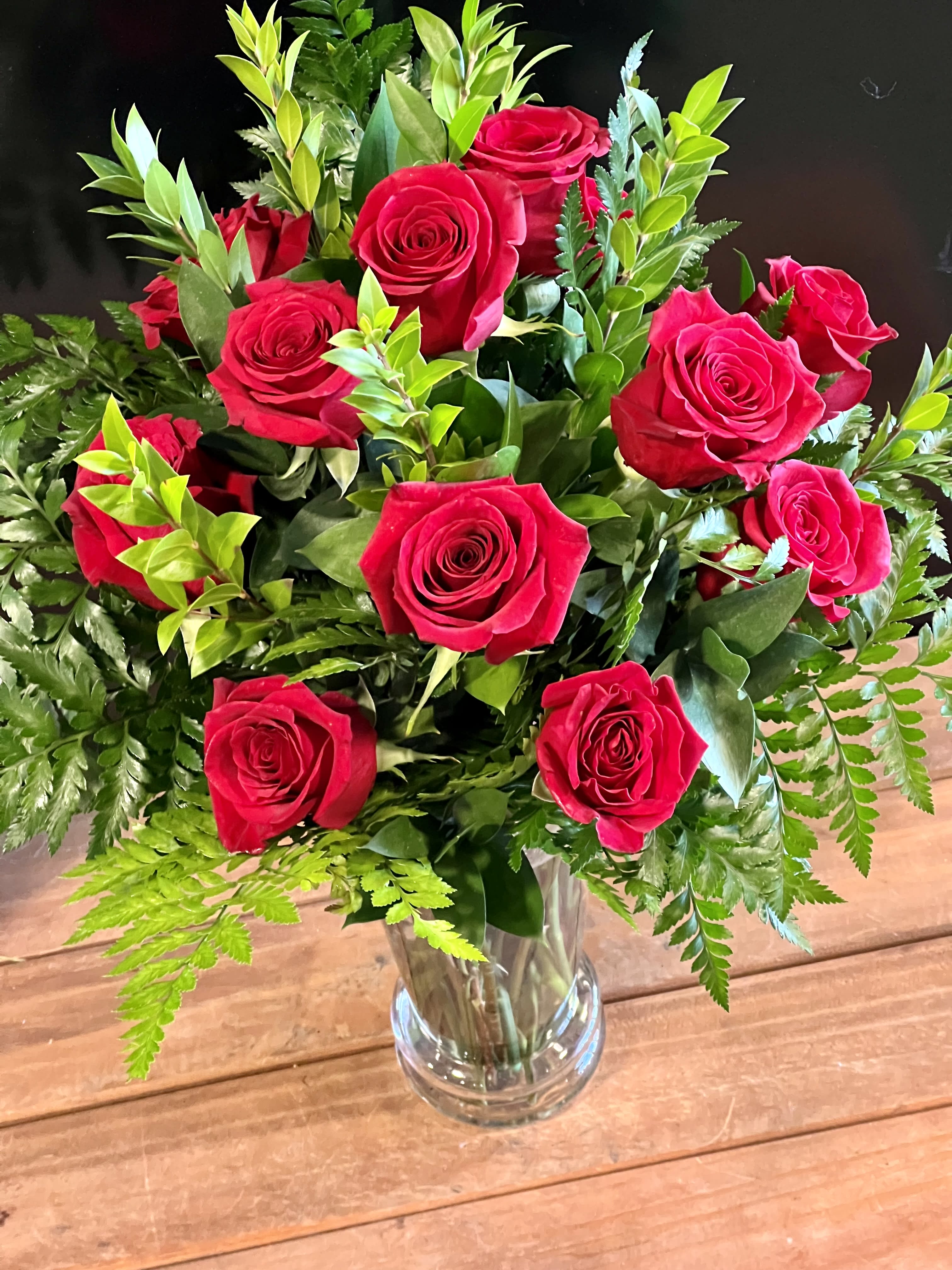 Traditional Dozen in Red - Turn up the romance with a dozen red roses! Premium long stemmed roses are designed beautifully with lush greens in a clear glass vase. Upgrade to 24 or 36 roses to really spoil them!  Vase is 10.5&quot; tall.