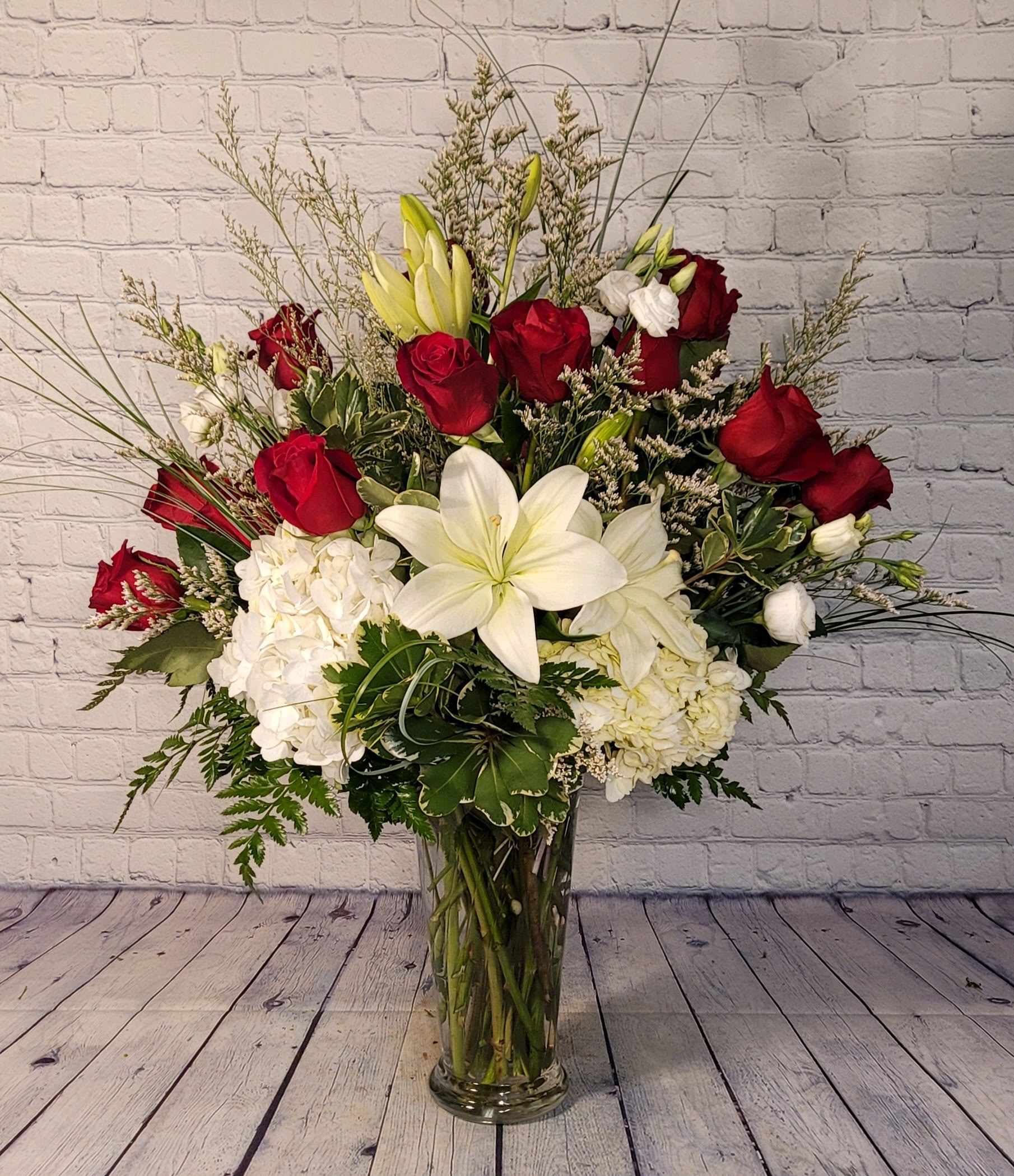 Crowned with Glory Crowned with Glory - This grand bouquet stands above the rest. With one dozen red roses, white hydrangea, white lilies, and white spray roses; you're sure to leave a lasting impression.