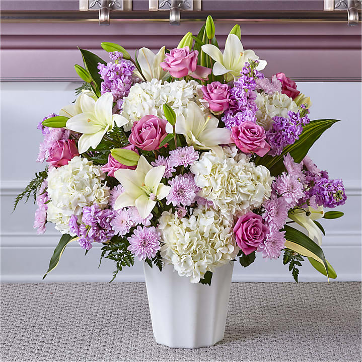Heaven Sent Floor Basket - Introducing the &quot;Heaven Sent&quot; Sympathy Floor Basket, a heartfelt and comforting arrangement designed to honor your loved one's memory. This exquisite arrangement features a delicate blend of white lilies, pink roses, lavender mums, white hydrangea, and lavender stock.