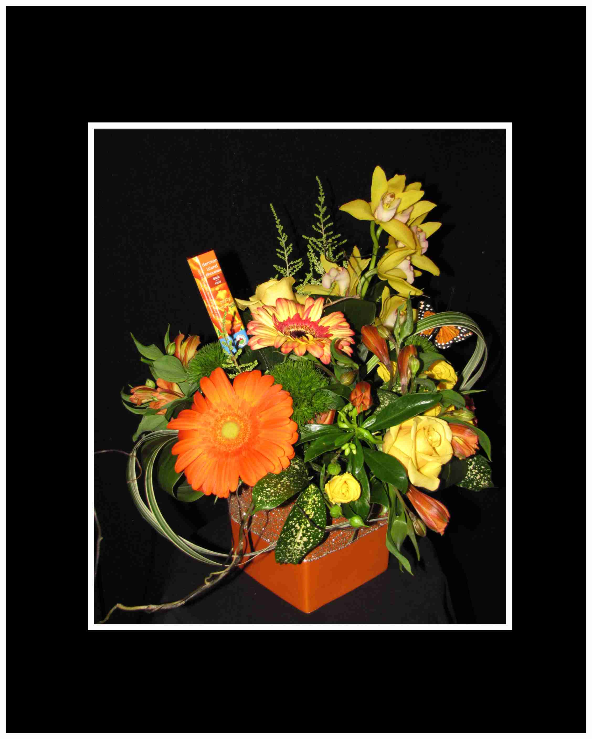Sweet Tangerine Bouquet Sweet Tangerine Bouquet - Bright and full of summer colors oranges and yellows all arranged in a orange ceramic container bright and cheerful. It also includes a fun Orange flavored Chocolate from Denman Island Approximately 16"H x 15"W.