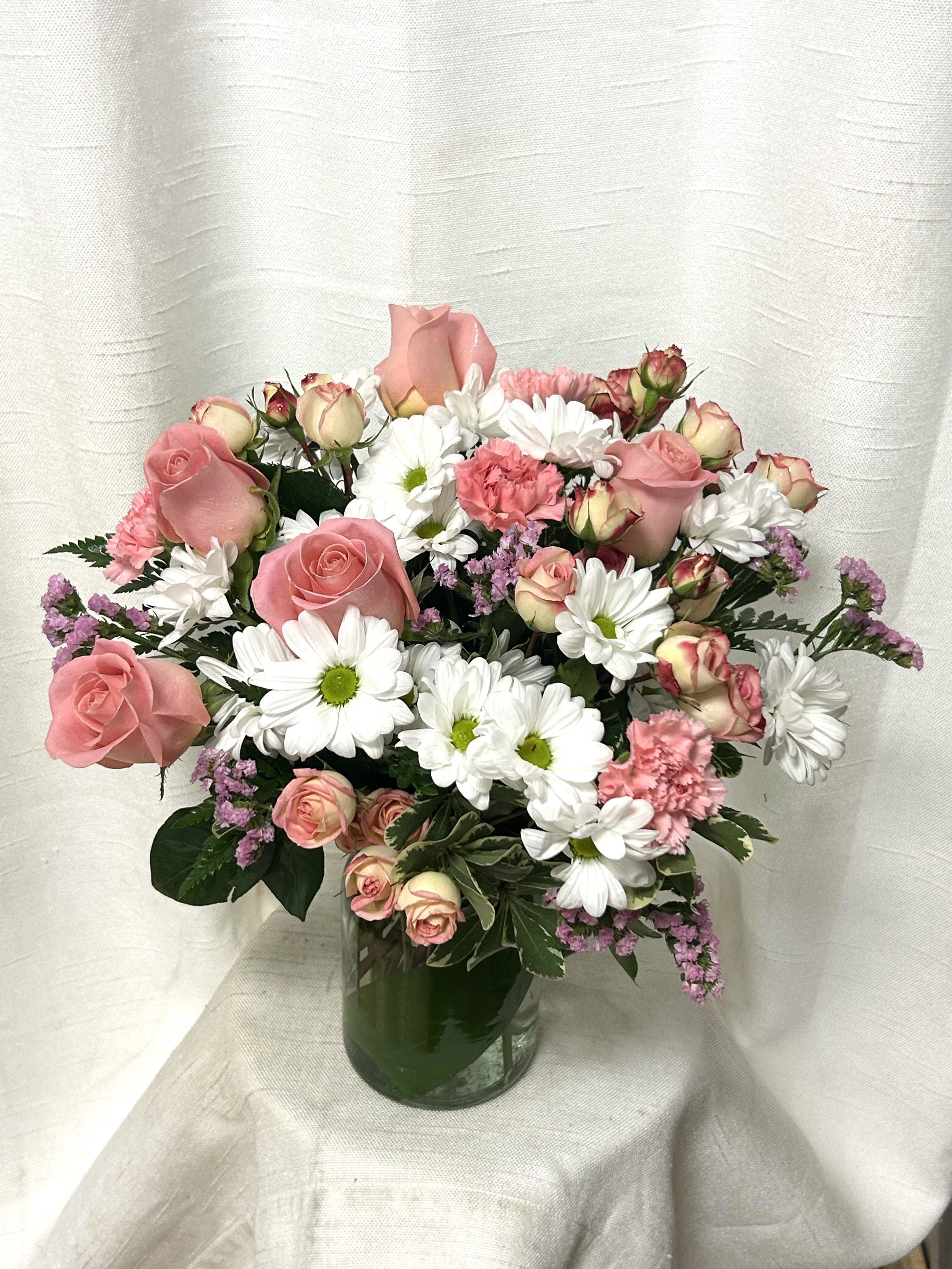 Sugar Rush - Indulge in the sweet serenity of the &quot;Sugar Rush&quot; arrangement, where delicate blooms of pink roses, white daisies, and pink carnations come together in harmonious beauty. This enchanting bouquet exudes a soft, romantic charm while invoking a sense of whimsical delight. The soft petals of the pink roses delicately blend with the cheerful white daisies and vibrant pink carnations, creating a visual symphony of color and fragrance. Perfect for brightening any space with its pastel hues and heavenly fragrance, the &quot;Sugar Rush&quot; arrangement is a delightful treat for the senses, evoking feelings of joy and bliss with every glance.