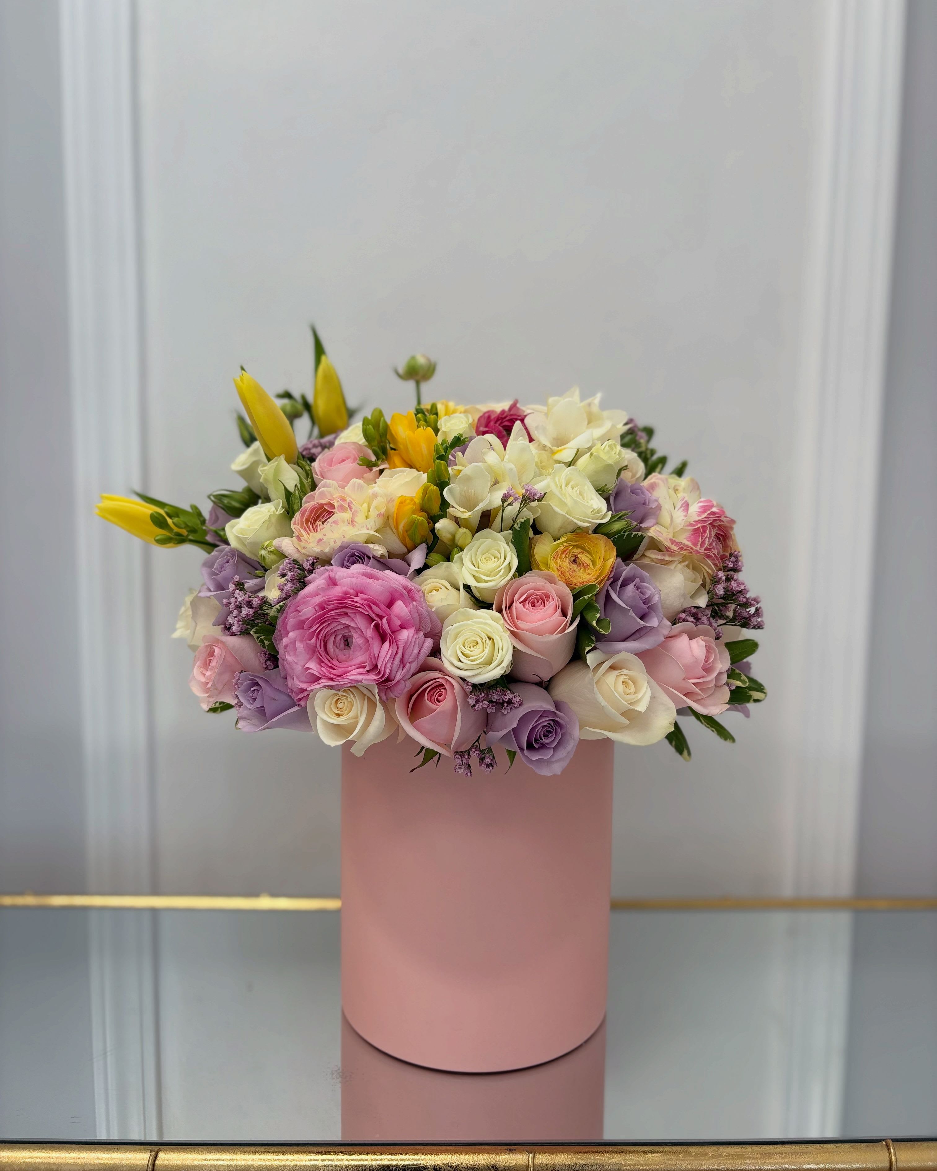 Spring Colors Hat Box By VLM Flowers Spring Colors Hat Box By VLM Flowers - This arrangement mixes pink, white, lavender, and yellow, making a perfect gift. The photo shown is in the standard size