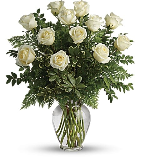 Joy of Roses Bouquet - A joyful gesture of love and affection, this chic arrangement of one dozen white roses lays with fresh greens, and is a special surprise on any occasion! Approximately 21 inches wide and 24 inches tall for the Standard size.