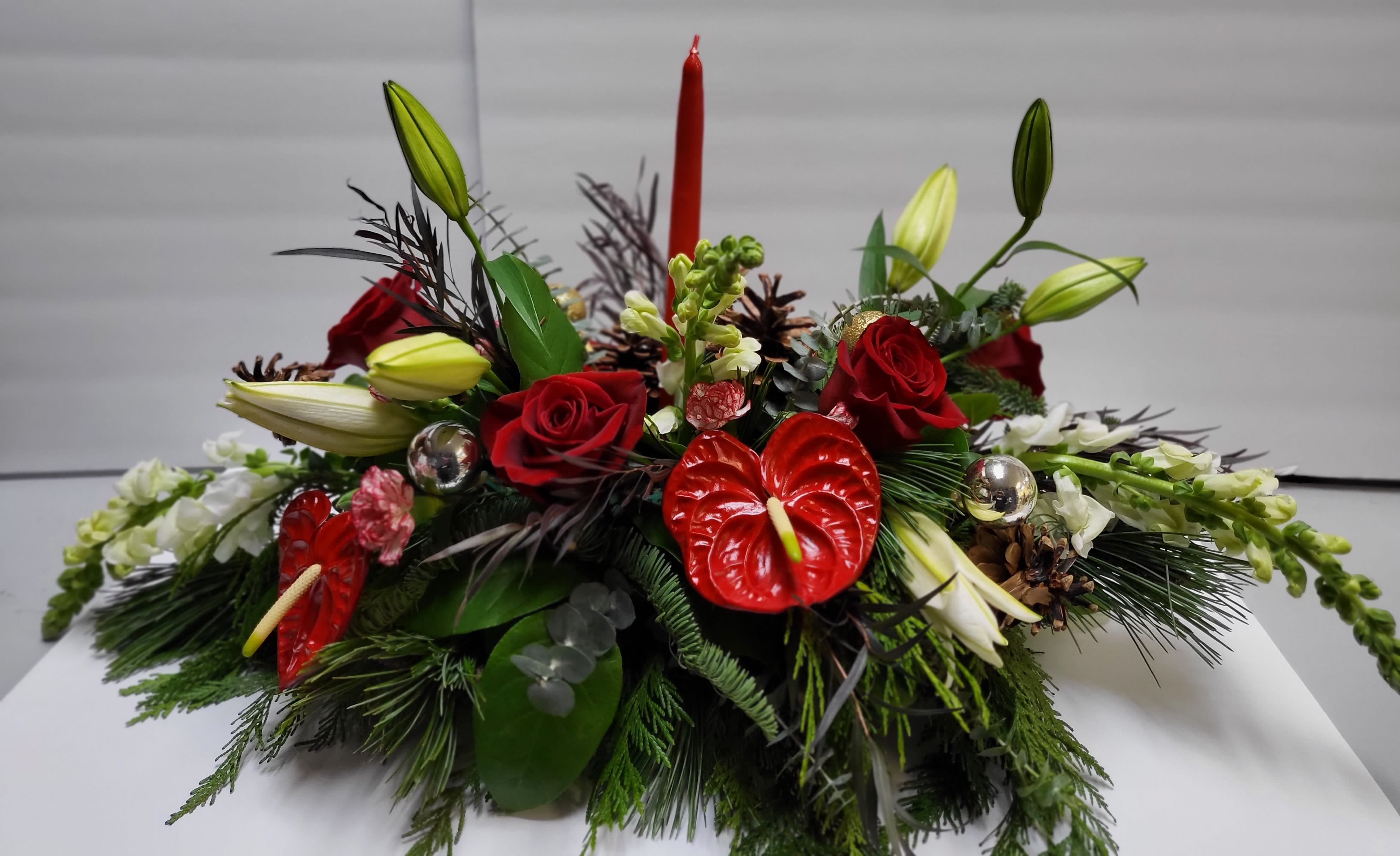 Christmas Fun Christmas Fun - This festive centerpiece designed with tapered candles, beautiful roses, vibrant, red anthurium, and snapdragons is perfect for any holiday gathering.