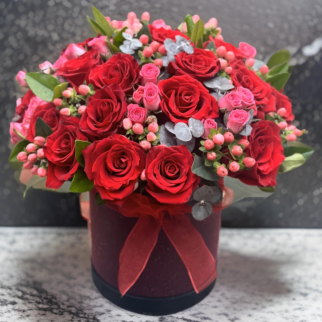 Red and Pink Roses in a Black Box - Experience the romance of our luxurious red and pink rose arrangement, artfully designed in a sophisticated black hatbox. This breathtaking bouquet combines vibrant red roses, delicate pink blooms, and lush greenery, creating a timeless gift perfect for any occasion. Accented with a velvet ribbon, this arrangement radiates elegance and charm.  Whether you’re celebrating an anniversary, expressing love, or sending a thoughtful gesture, this premium floral design from Lotus Event Decor makes every moment unforgettable. Crafted with care, it’s ideal for enhancing special events or decorating your home with a touch of luxury.  Order today for fresh flower delivery in Los Angeles and nearby areas. Let our exclusive floral creations elevate your celebrations.