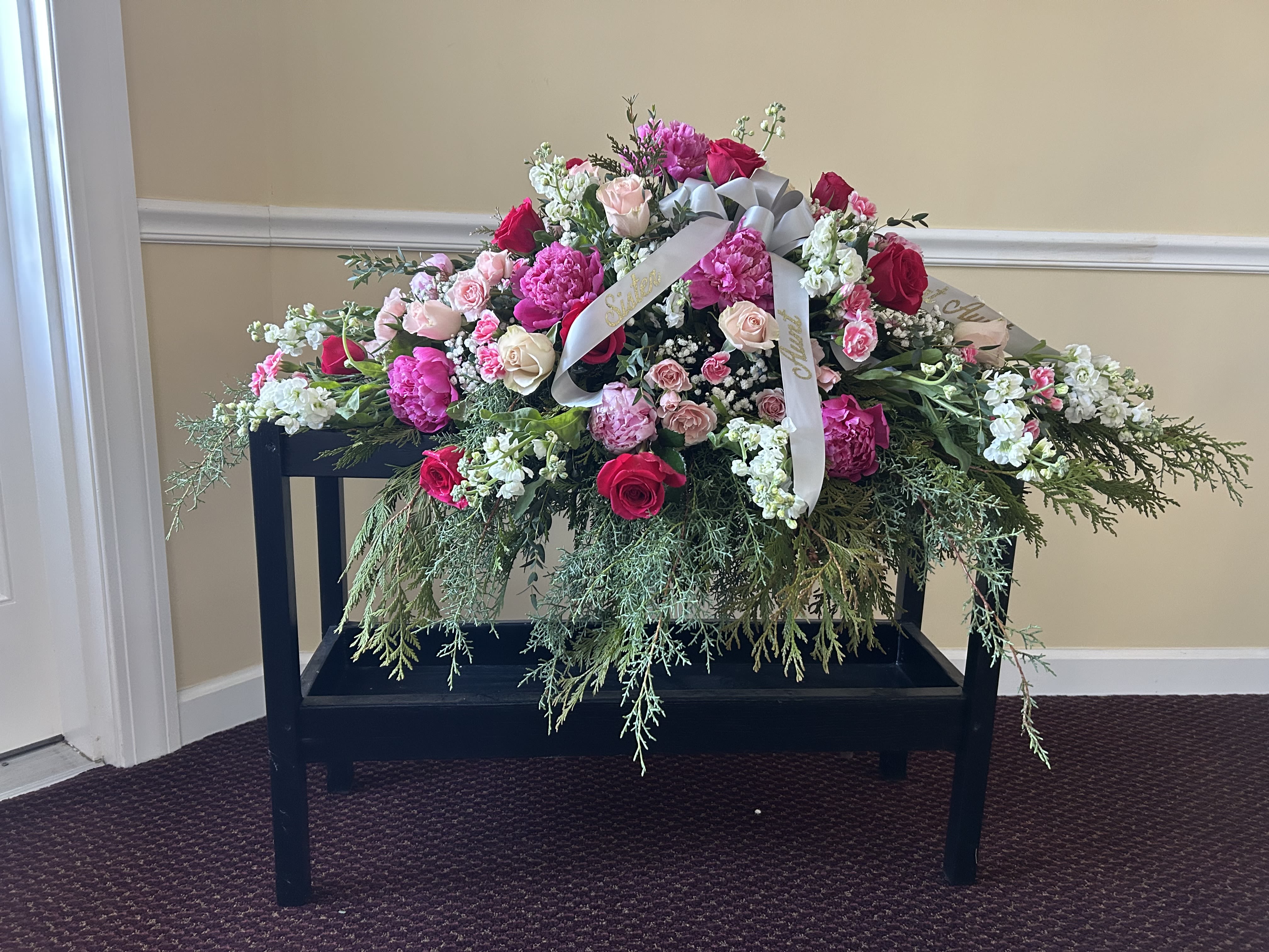 She loved pink - A full casket spray in shades of pink;  peonies, roses, carnations, spray roses, stocks
