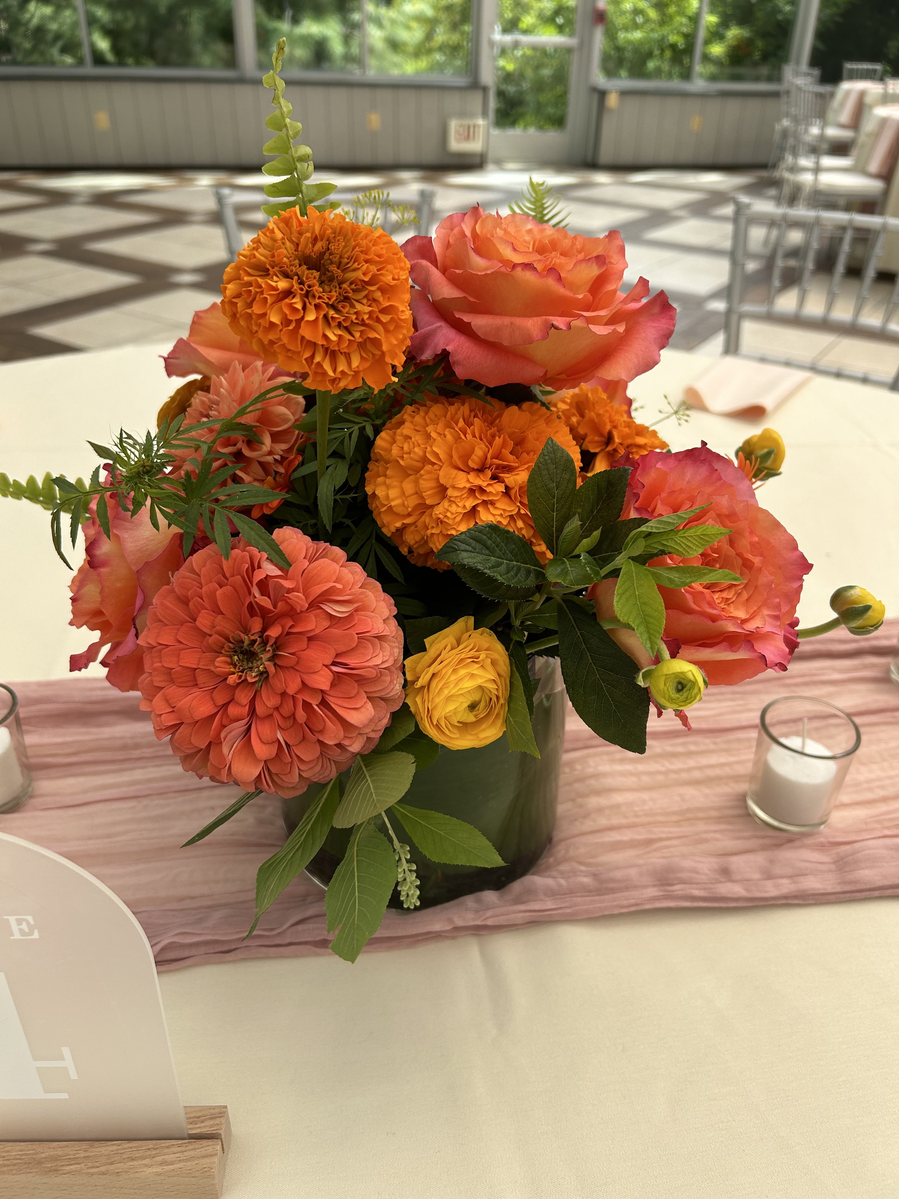 Summer Citrus  - A bright beautiful arrangement made in citrus shades of zinnias, marigolds, roses, and ranunculus 