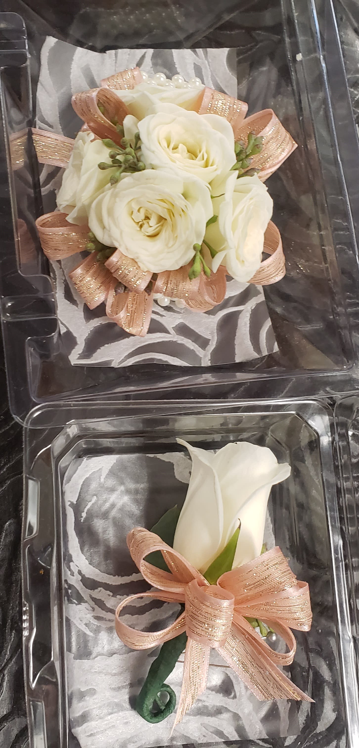 Rose Gold wrist corsage and boutonniere combo - Rose Gold wrist corsage and boutonniere combo - - Rose Gold wrist corsage and boutonniere combo In this order you will get both wrist corsage and pin on boutonniere. White spray roses for the wrist corsage designed on a iridescent Slap wristlet , rose gold sparkle ribbon and babies breath. The Boutonniere will be made with a large white roses to match wrist corsage will add same ribbon. NO SAME DAY ORDERS