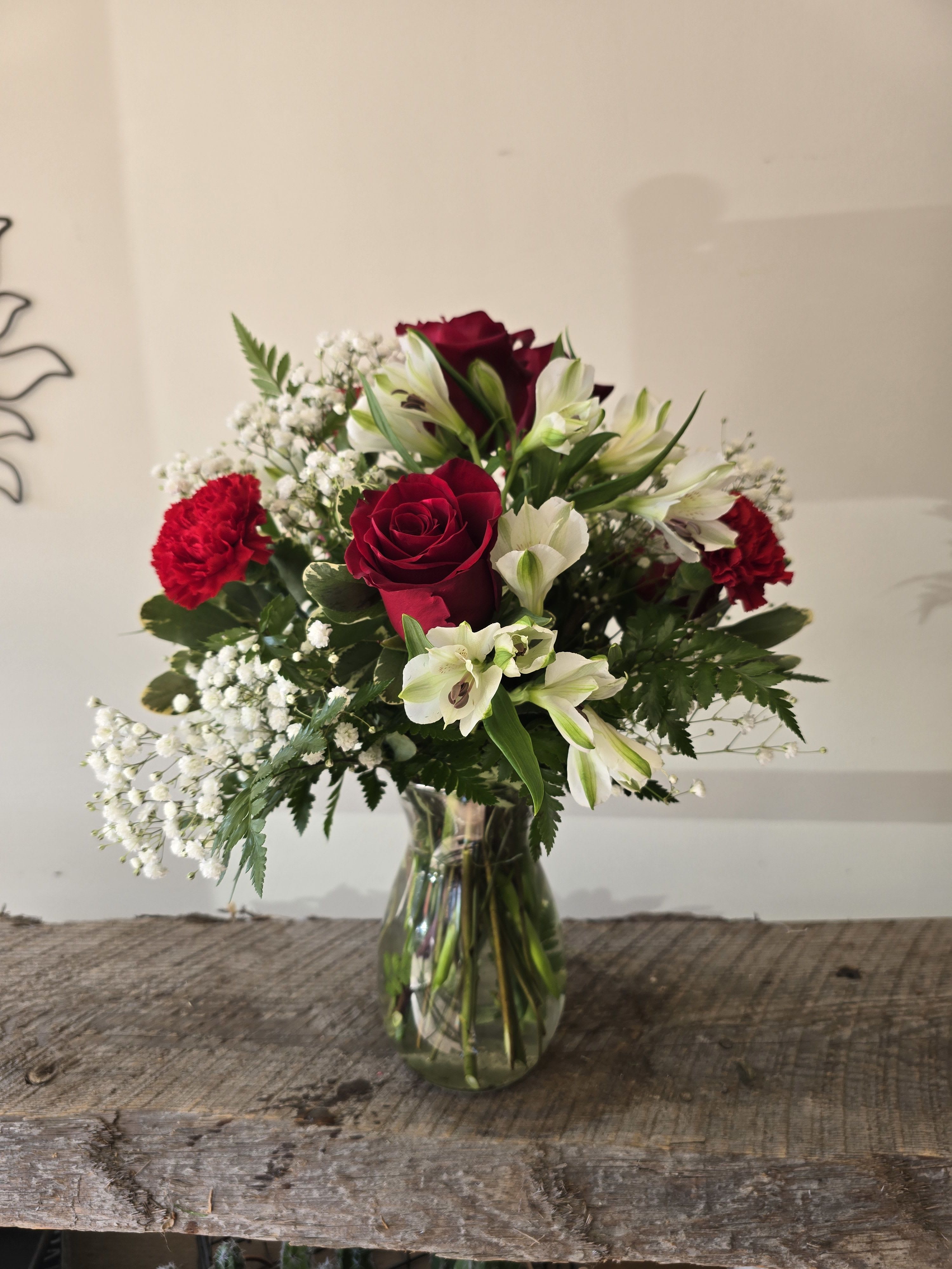 Glamor Glamor - A medium vase with 6 red roses, white alstro, red carnations ave gypsum.