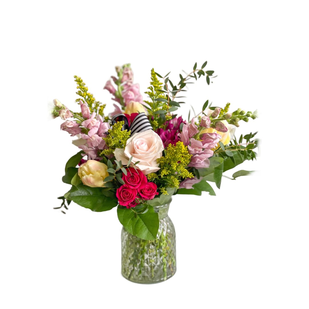 Sandy  - Sandy is a clear glass vase made up of snapdragons, roses, tulips (when available), alstroemeria, and greenery! 