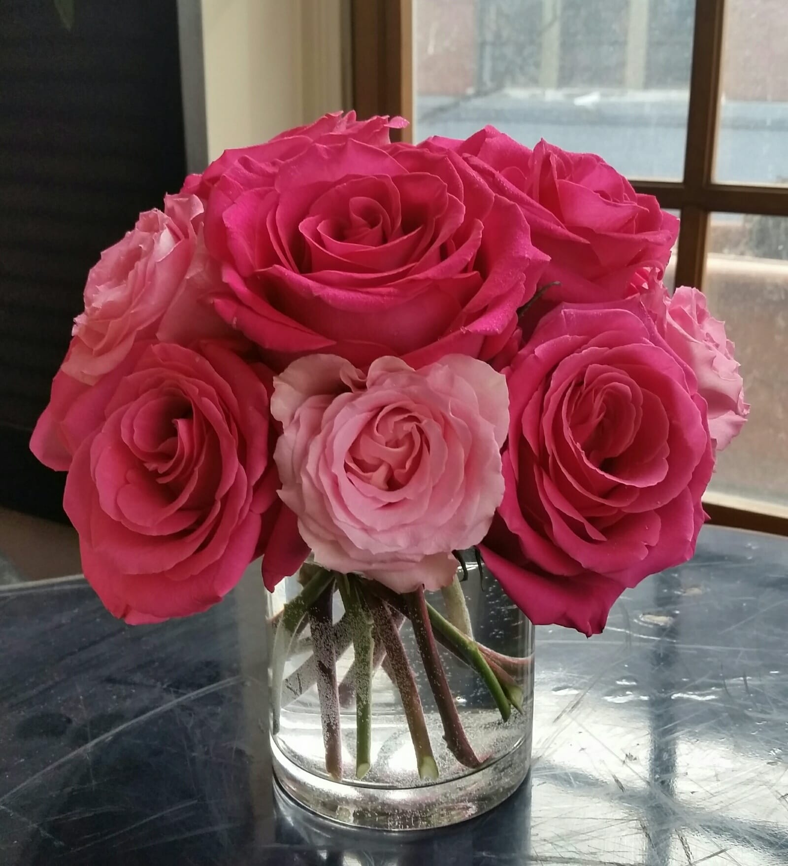 Rosy Cheeks Rosy Cheeks - A sweet arrangement of all blush and hot pink roses in a clear glass cylinder.
