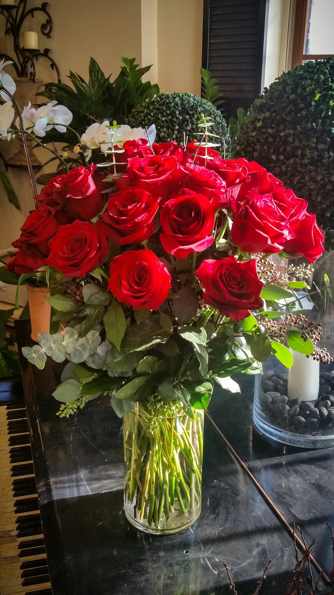 Times Three Times Three - A showstopper arrangement featuring three dozen tall premium red roses complemented by soft greenery in a clear glass vase.