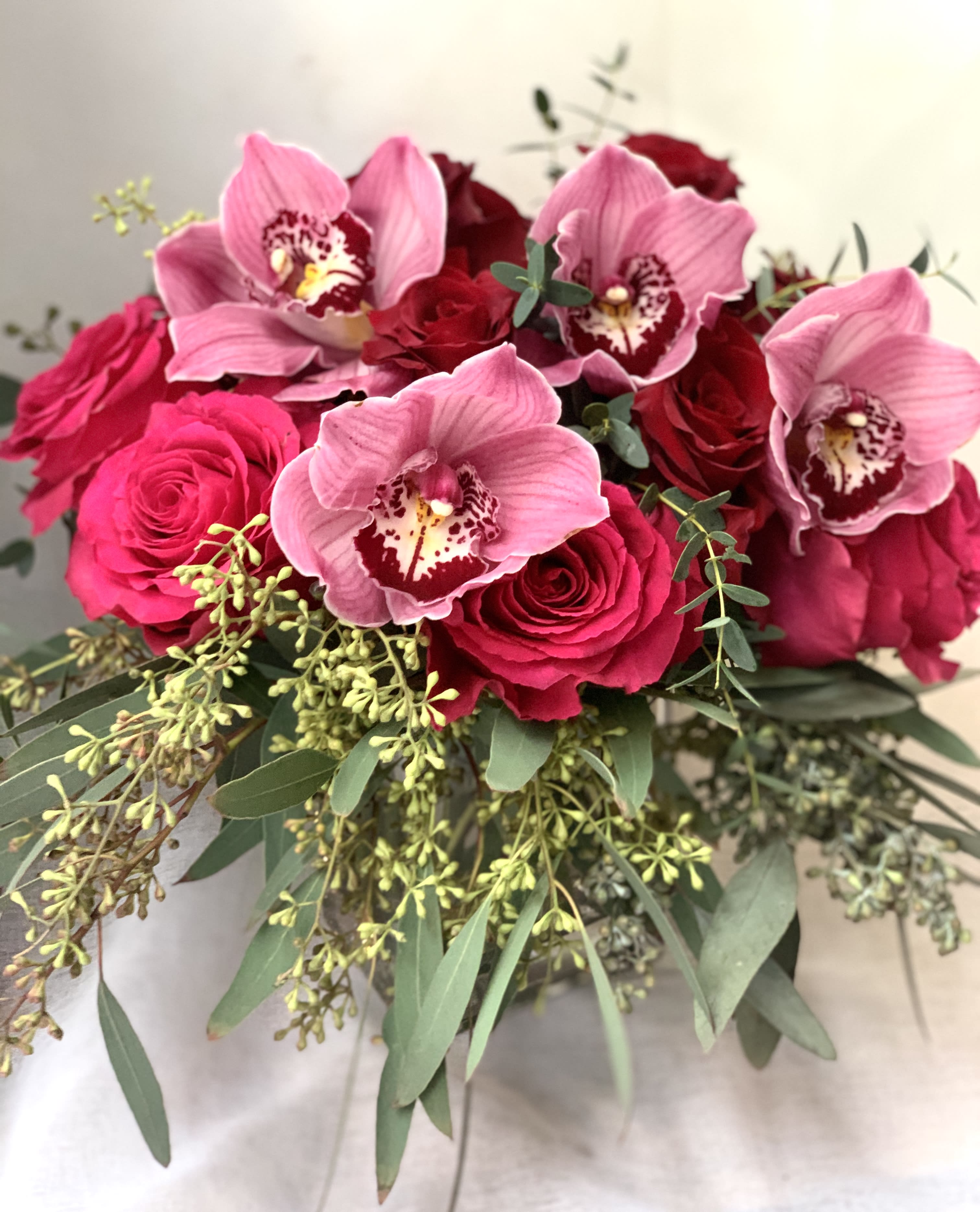 Adore -  Hot pink  and  red  roses with pretty pink cymbidium orchids