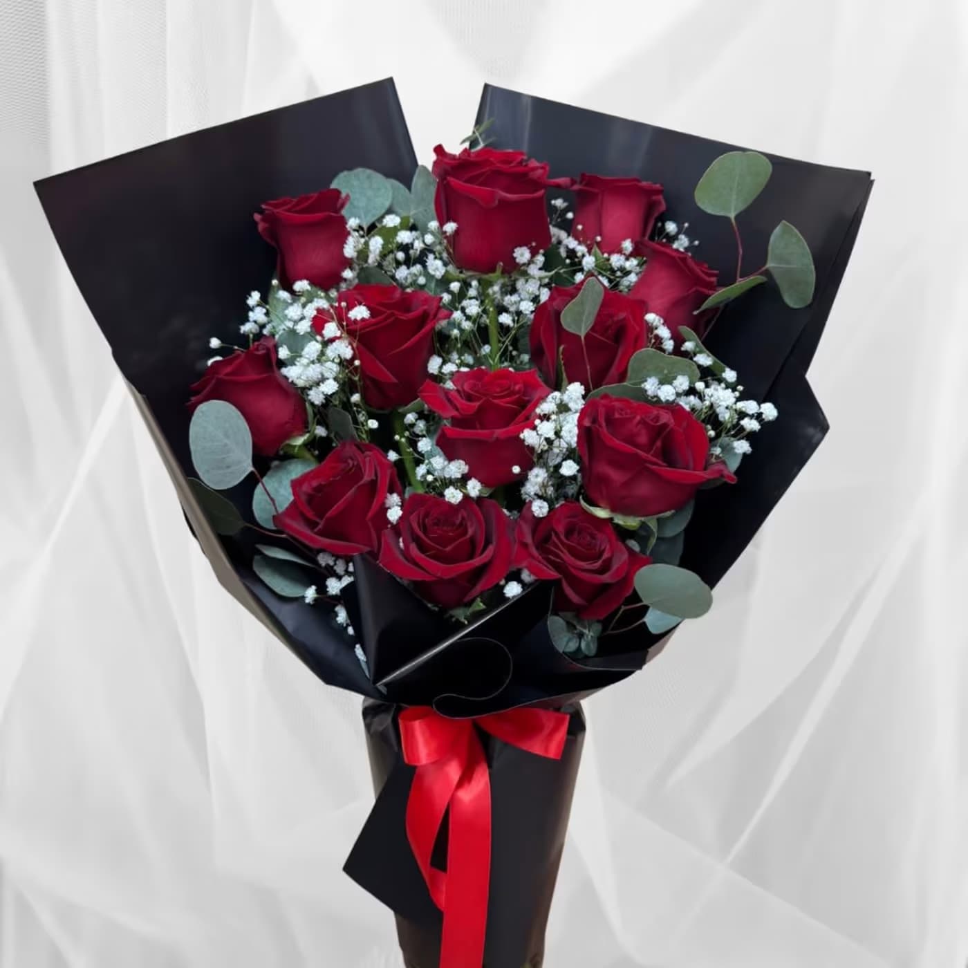 Red Rose Luxe Wrapped Vase Red Rose Luxe Wrapped Vase - One faced vase arrangement with 12 roses and filler wrapped in wax wrap.