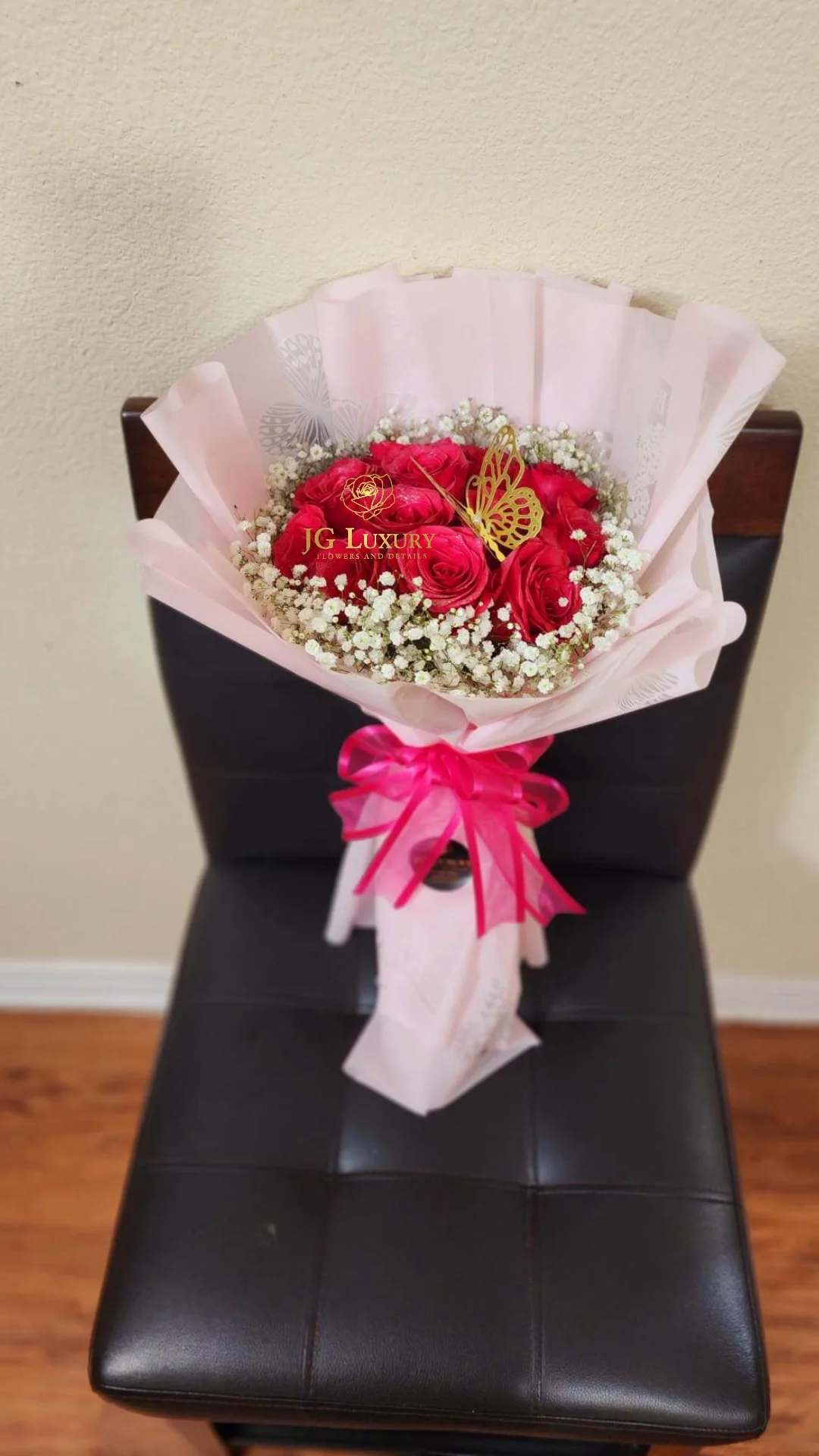 Amore Farfalla - A dozen hot pink premium roses surrounded by baby's breath tied tight with love with a lovely butterfly pick on top.