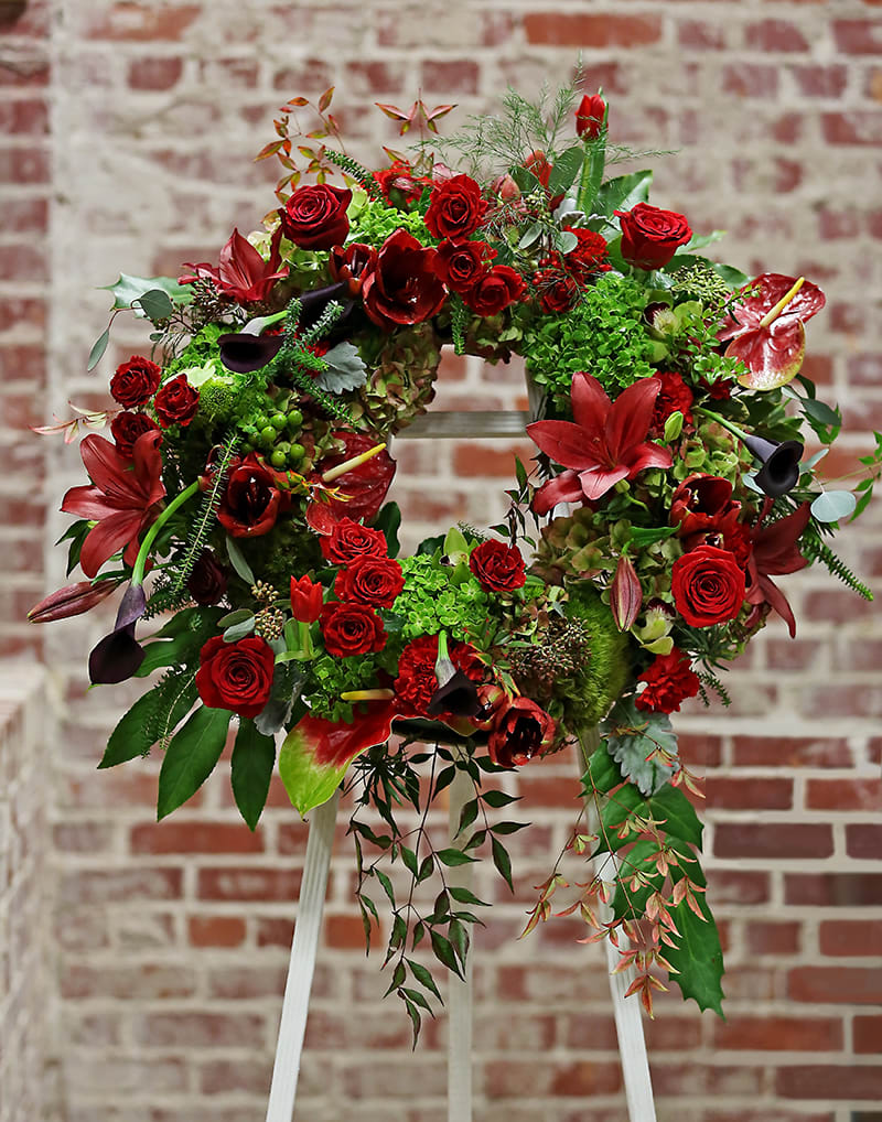 Circle of Life Circle of Life - A stunning tribute to a loved one or colleague. This wreath features a variety of flowers, foliages, mosses and berries in reds and greens and creates a dramatic statement piece.