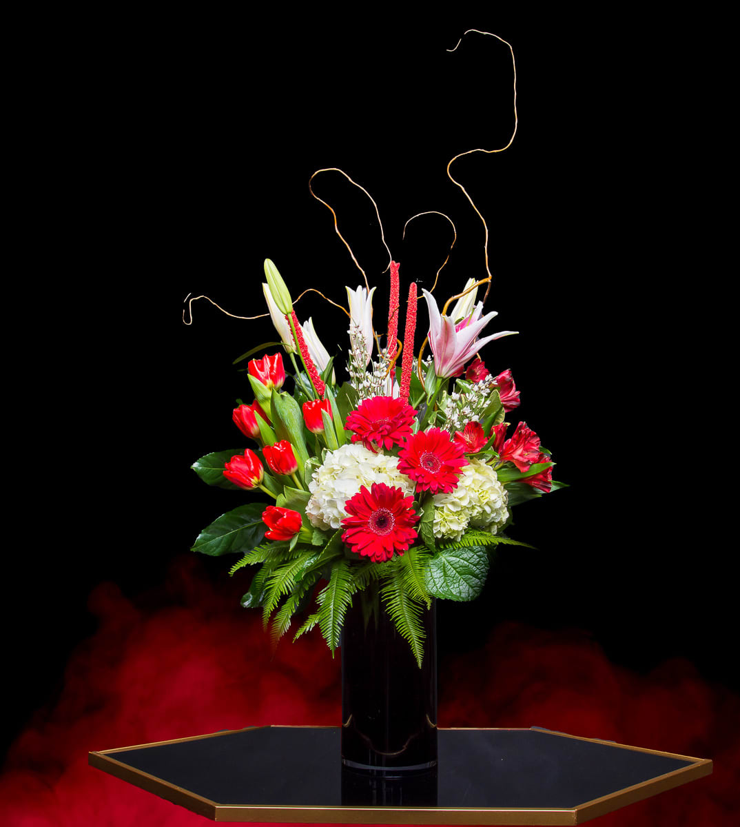 Lady on Fire  - This Lovely Chic Tall Arrangement will light her eyes upon arrival with its breath taking beauty. With lush white Hydrangeas, tulips, Lilies and Gerbera Daisies. In our classic Tall Black Vase. 