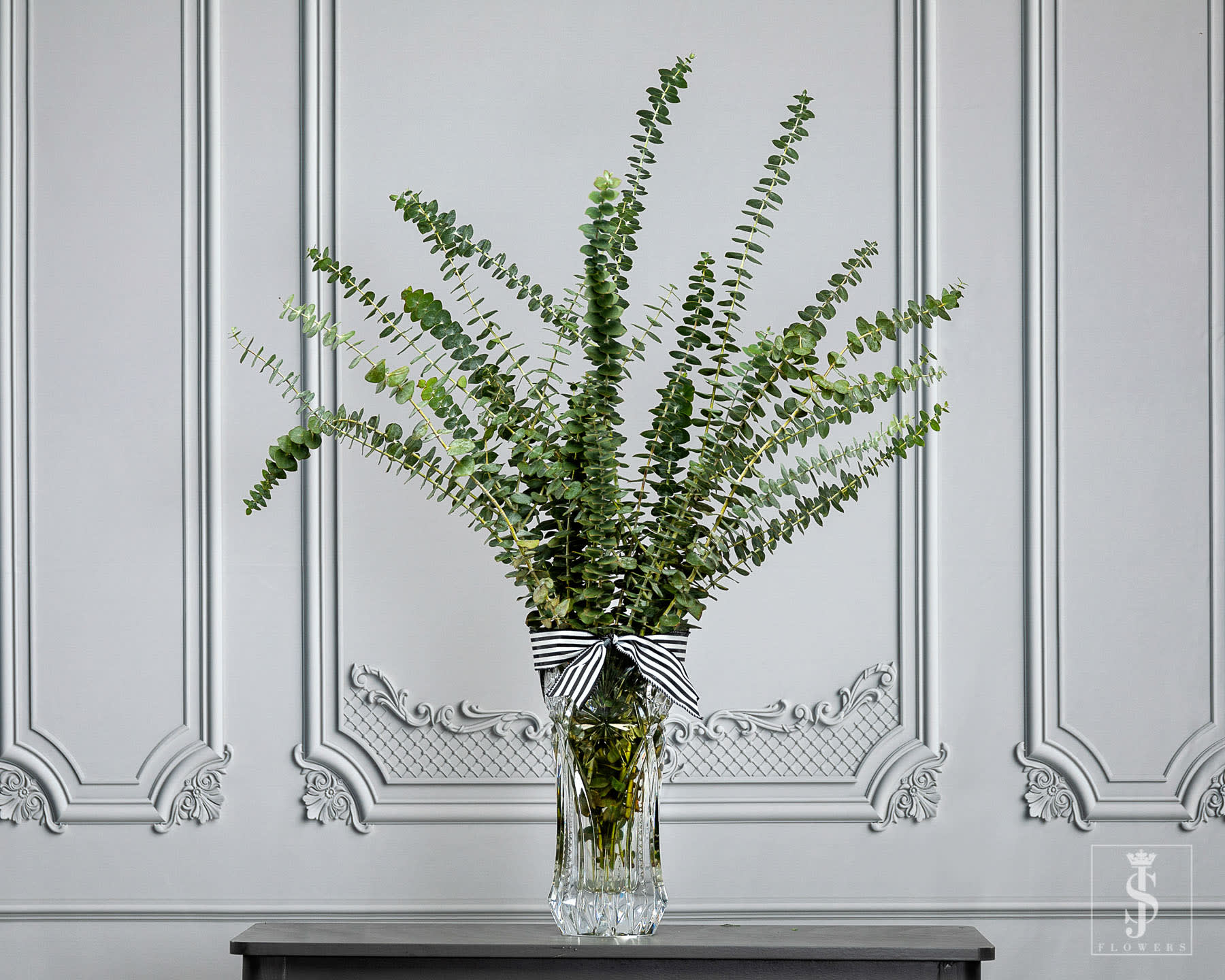 Eucalyptus Baby Blue Greenery - This item is sold by the bunch. [yoo-ka-lip-tus] This Classic vase and the bunch of Eucalyptus dose wonders in you home. It have a strong fragrance that relaxes you. Eucalyptus in your bathroom and or shower is to refreshing and a breath of fresh air. One of the most important elements of a floral arrangement is that bit of greenery that ties everything together. Baby blue eucalyptus is an example of such a type of green filler that adds that finishing touch. Characterized by small, delicate leaves, baby blue eucalyptus is a popular choice for DIY brides and party planners who are searching for a refined type of foliage to add to their bouquets, centerpieces, and ceremonial décor. Eucalyptus is very hardy and holds up exceptionally well under various conditions. While they are durable, do your part by allowing them to rehydrate in warm water, and misting them with clean water every day before your event to ensure freshness. Eucalyptus also works well in dried arrangements for a long-lasting bouquet that also emits a distinct scent. When it comes to incorporating them into your floral creations, you are only limited by your imagination. We have seen breathtaking  arrangements where baby blue eucalyptus was surrounded by an abundance of spray roses, ranunculus, and hydrangeas for a lush, cascading bouquet. We have also seen them in a much simpler, rustic arrangement with lisianthus, seeded eucalyptus and blue thistle. Whatever your floral vision, baby blue eucalyptus can help make it happen.   Send your Beautifully Wrapped Fresh Flowers today. The stems will arrive wrapped in  JS Flowers tissue and cellophane.. **Please note the vase is not included!   Important Information:  * Orders placed on Monday will process on Tuesday for Wednesday delivery.  * Orders placed on Tuesday will process on Wednesday for Thursday delivery.  * Orders placed on Wednesday will process on Thursday for Friday delivery.  * Orders placed from Thursday to Sunday will process on the following Monday for Tuesday delivery.  * Orders will not be delivered on Saturdays and Sundays.   All flowers are Shipped/Delivered during their freshest state so that you can enjoy them for as long as possible! Please be aware that upon arrival flower heads will be tight, allowing you to enjoy every moment of them maturing into full blooms! Photos displayed on this website are taken during each flowers most mature state.  