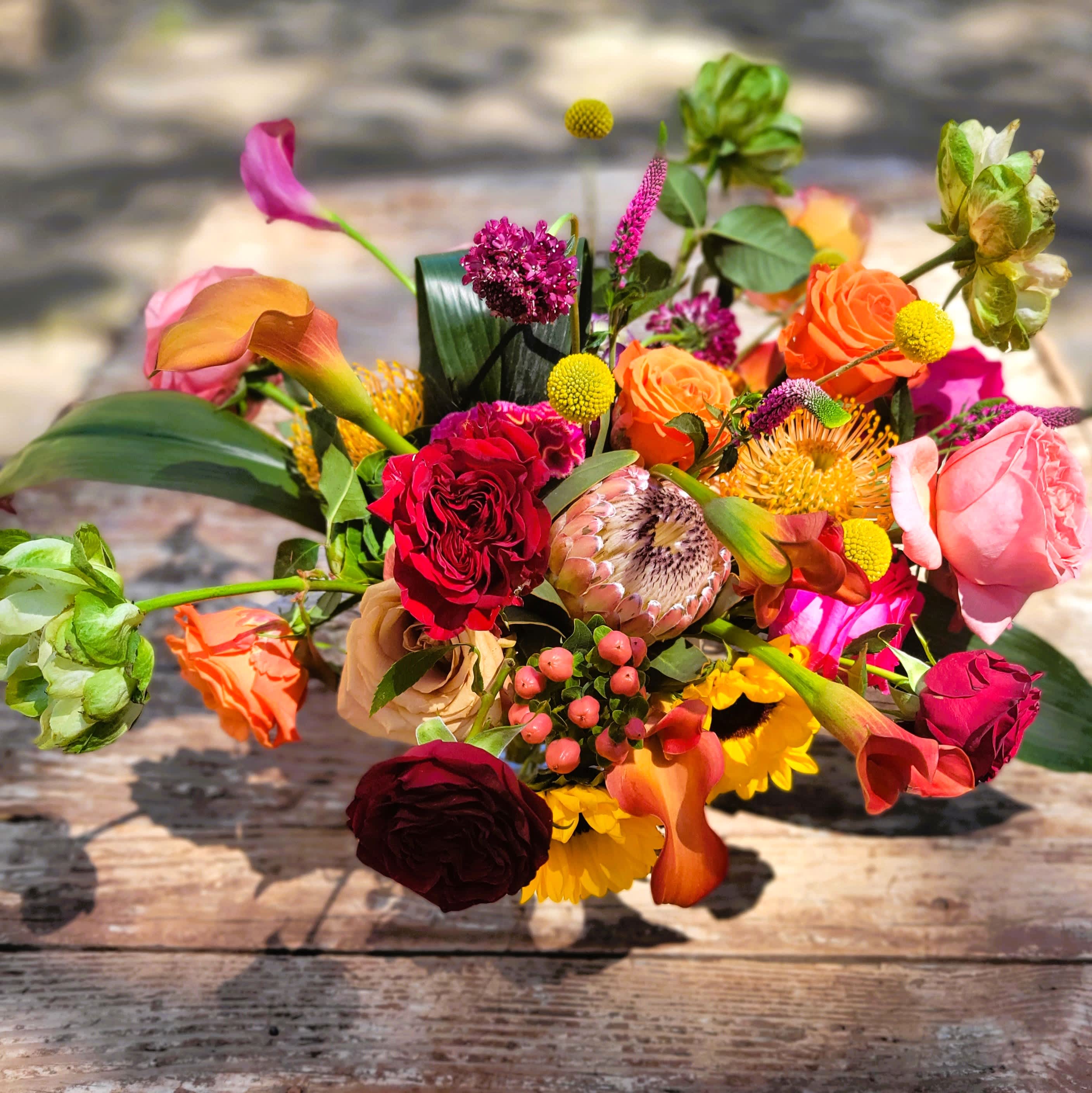 Havana - Fiery combination of hot vivid colors and unique foliages designed in a clear glass container with exposed stems.