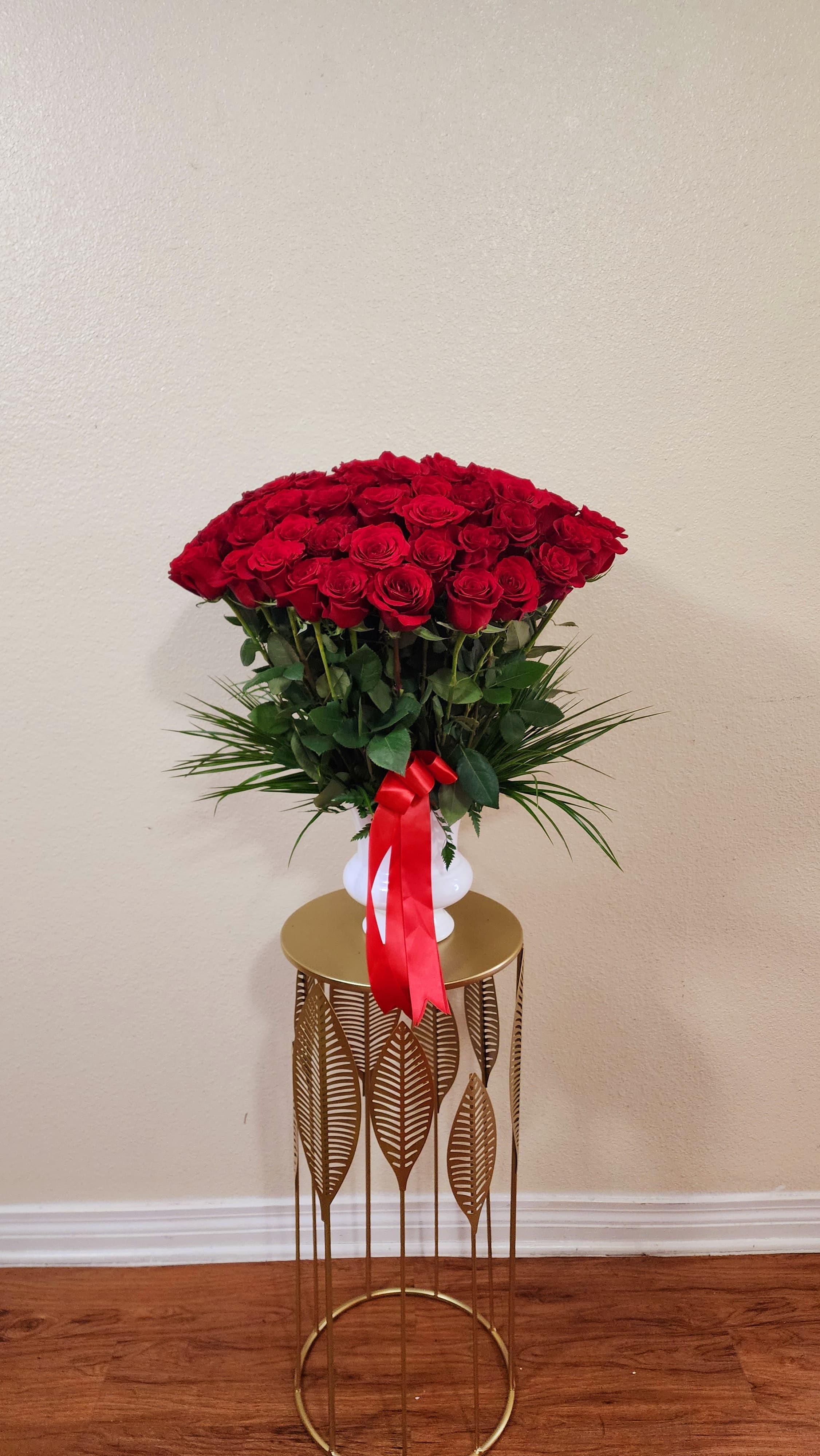 Lovely Done - Roses arranged in a white vase with greens.