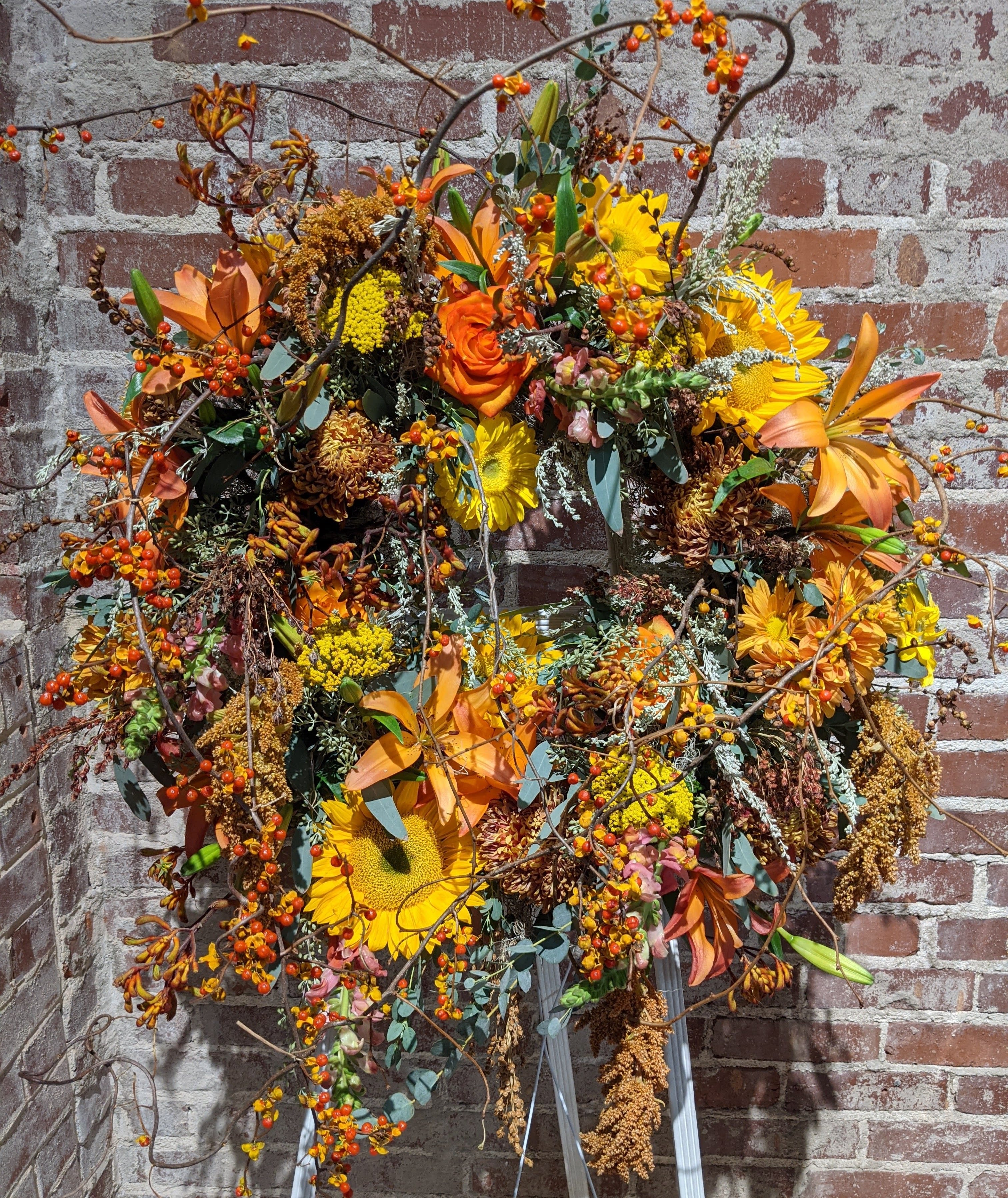 Into the Woods Memorial Wreath Into the Woods Memorial Wreath - An organic floral tribute for the deceased. A warm palette of earth-tone components including berries, pods and vines accented with rich green foliages create a unique statement for this celebration of life. Additional color palettes are available upon request. 48 hours notice is required for a color substitution. Please call the shop at 404-314-6194 to discuss.