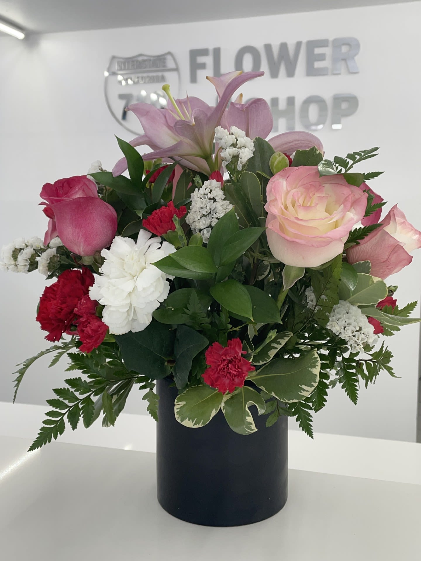 Blush Garden Delight - A mix of soft pink roses, lilies, red carnations, white flowers, and lush greenery. (If you'd like to change any colors please leave note in instructions. If some flowers and/or the vase are not available there will be minor substitutions.) 