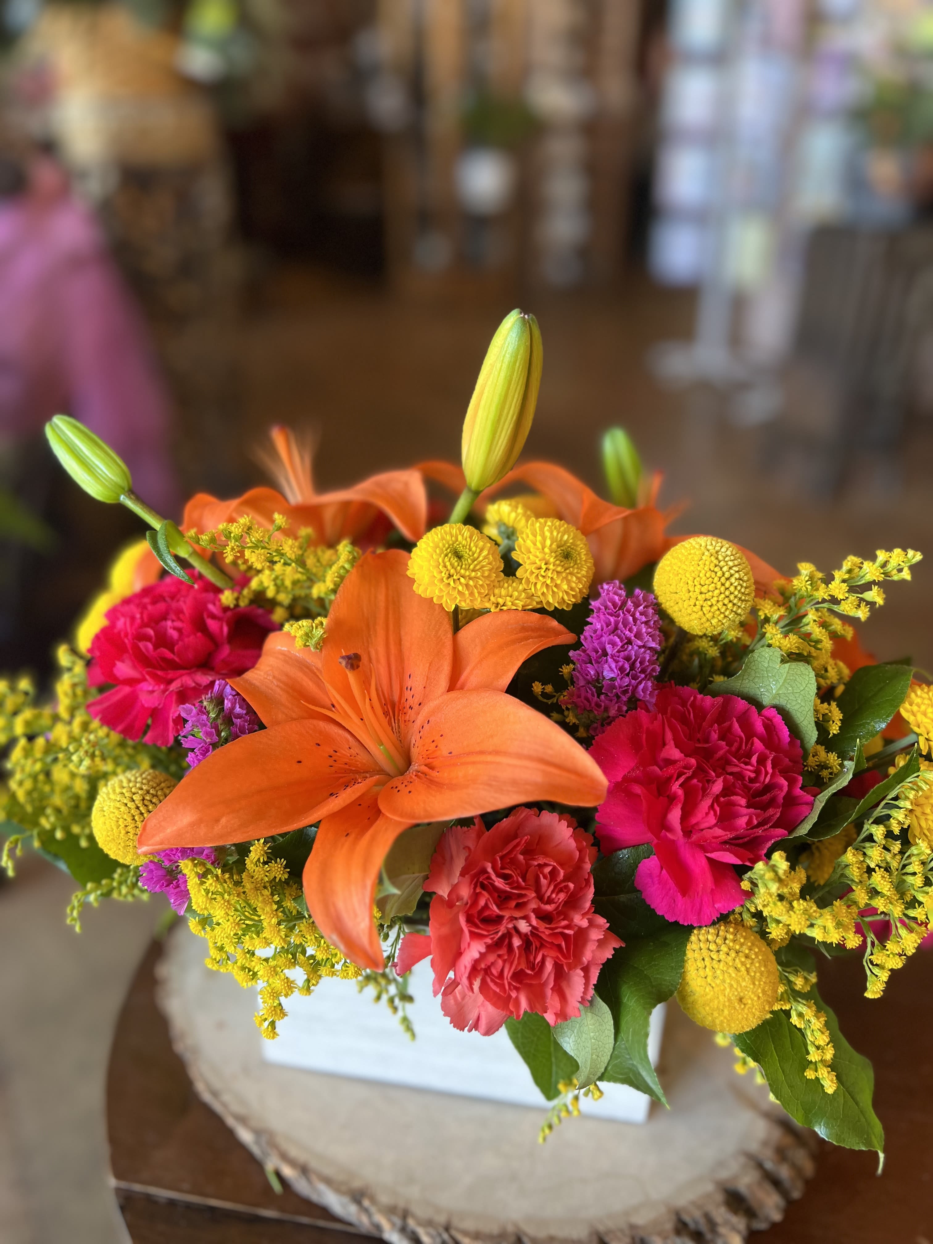 Summer of '69  - This bold, bright, and fiery boxed arrangement contains orange day lilies, solidago, hot pink and orange carnations, yellow button poms and more! 