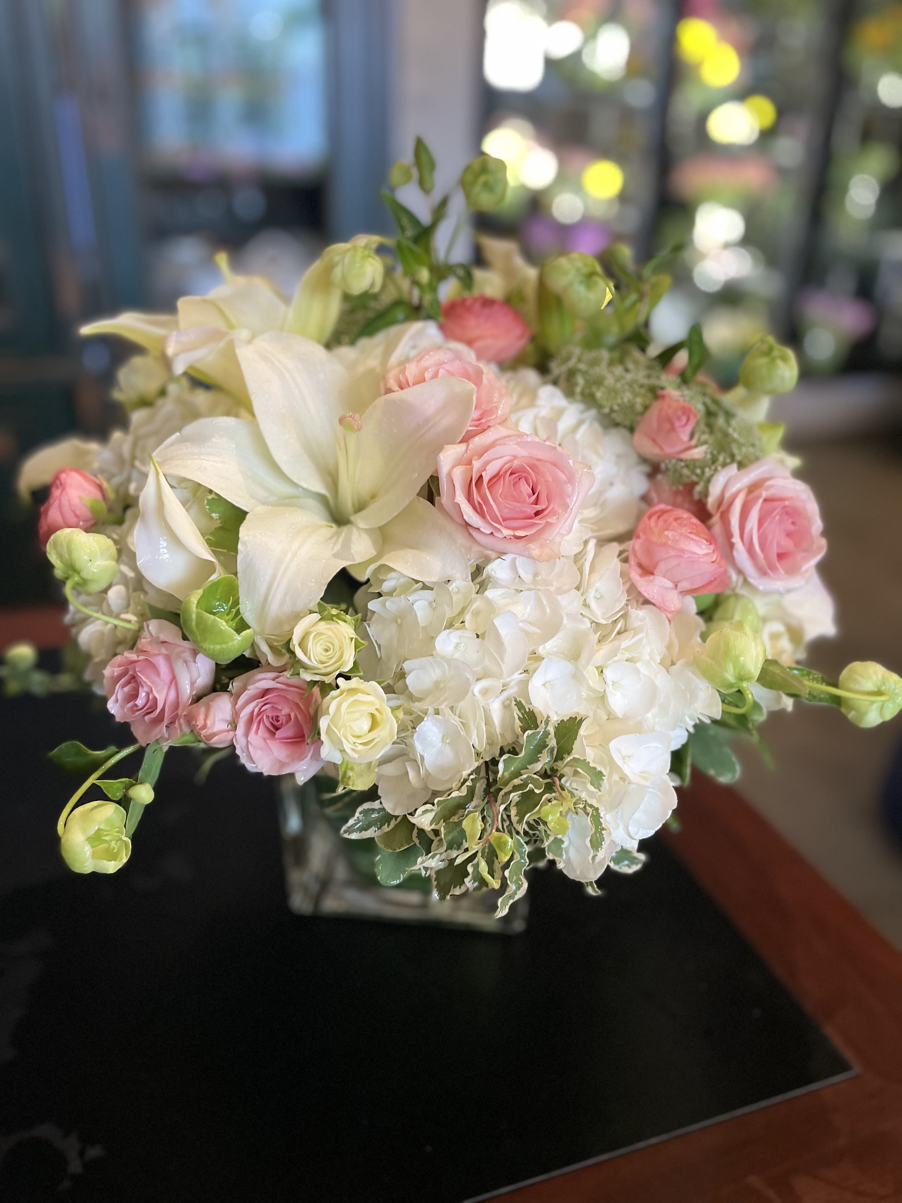Sugar Rush - One of our most popular arrangements, Sugar Rush is the sweetest way to brighten anyone’s day. This whimsical, elegant bouquet features pristine white hydrangeas, soft pink spray roses, lovely green hellebores, and the best seasonal blooms—beautifully arranged in a chic glass cube vase. Whether for Women’s Day, Mother’s Day, a birthday, or just to make someone smile, Sugar Rush is the perfect way to elevate any space with its charming colors and fresh appeal.  Please note: Seasonal flowers may vary based on availability, ensuring each arrangement is unique and fresh.  Freshness Guarantee: At Belden's Florist, we stand behind the quality of every arrangement. Our flowers are guaranteed to remain fresh and beautiful for 3–5 days after delivery. While cut flowers may naturally begin to wilt beyond this timeframe, we ensure that only the freshest blooms are selected and expertly arranged to bring joy and elegance to your space. To extend their life, we recommend refreshing the water in your vase daily, allowing your flowers to stay hydrated and continue to dazzle.
